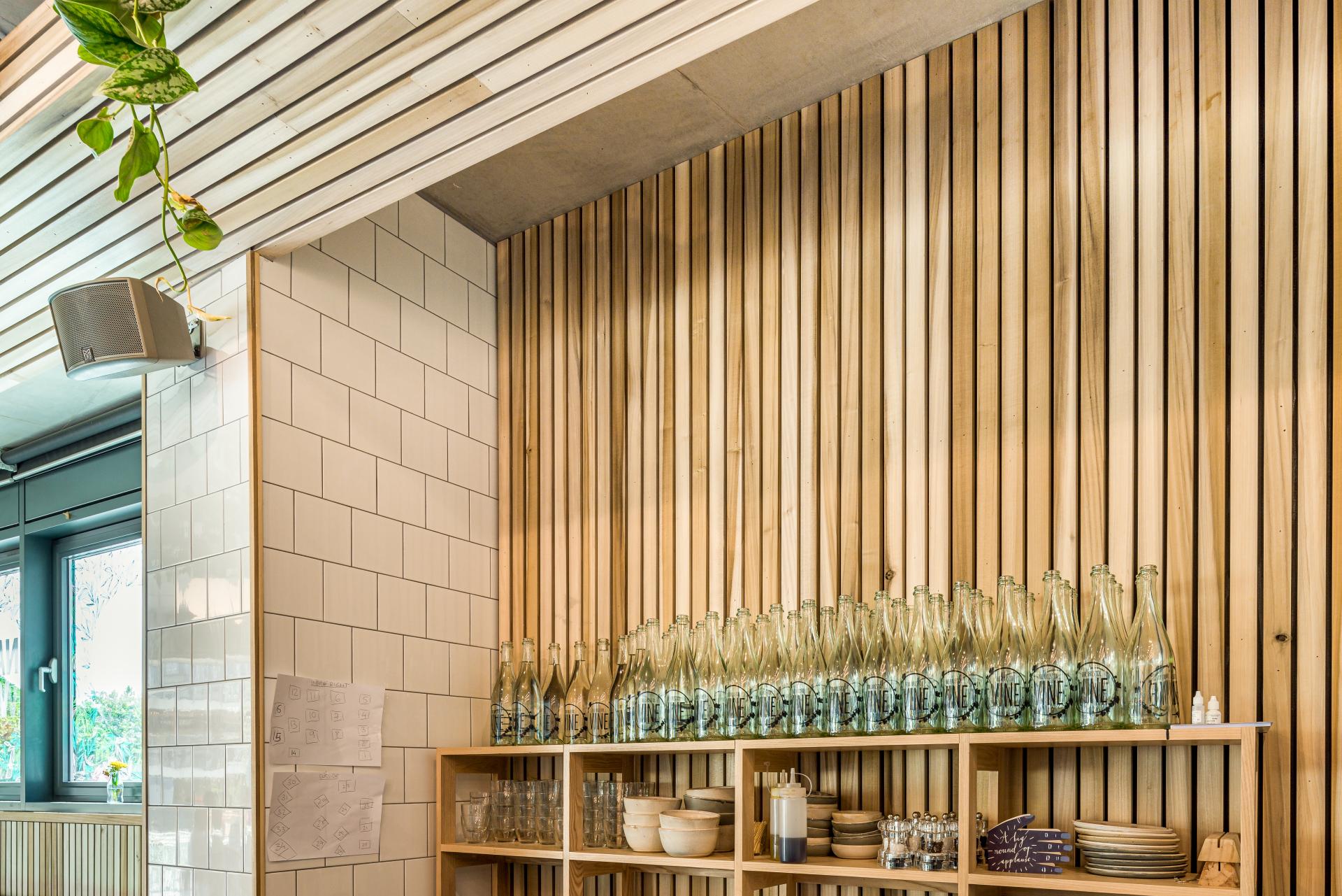 Interior of Bristol Loaf cafe featuring wooden paneling, glass bottles, and ceramic dishware on shelves.