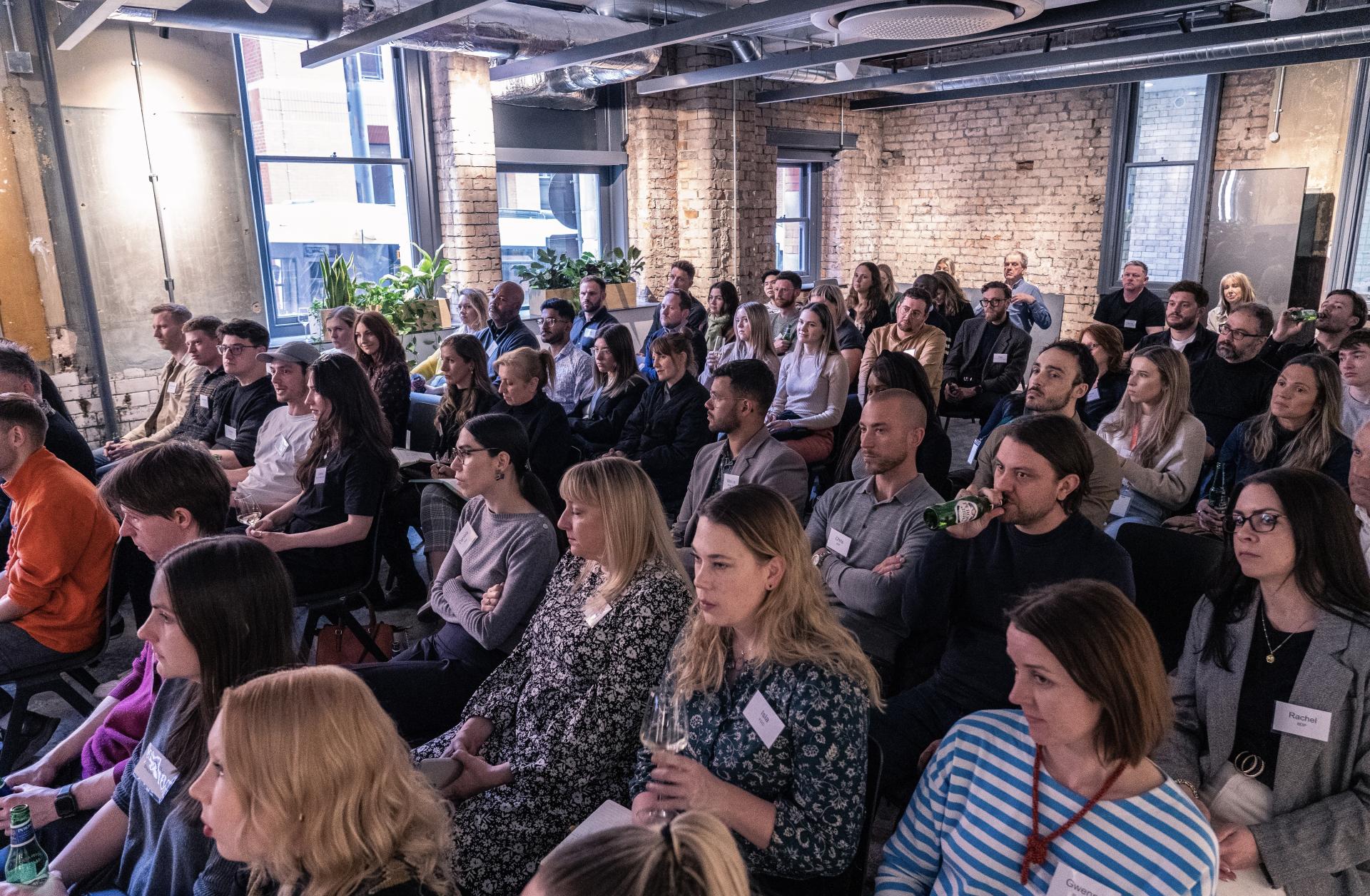 Audience engaged in a technology presentation at Material Source Studio, showcasing diverse participants and an interactive atmosphere.