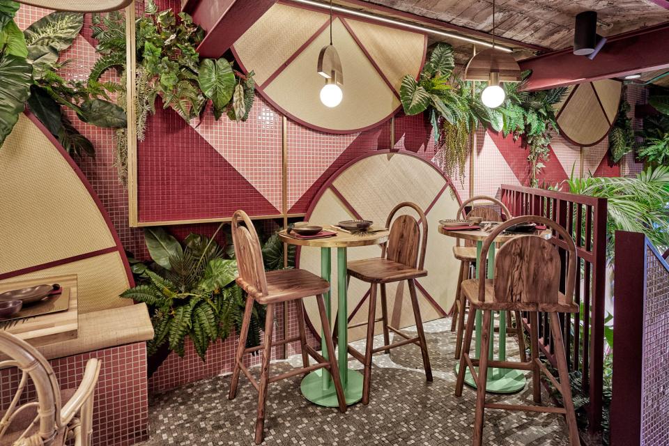 Tropical-inspired interior design featuring vibrant tiles, greenery, and wood accents in Kaikaya sushi restaurant, Valencia.
