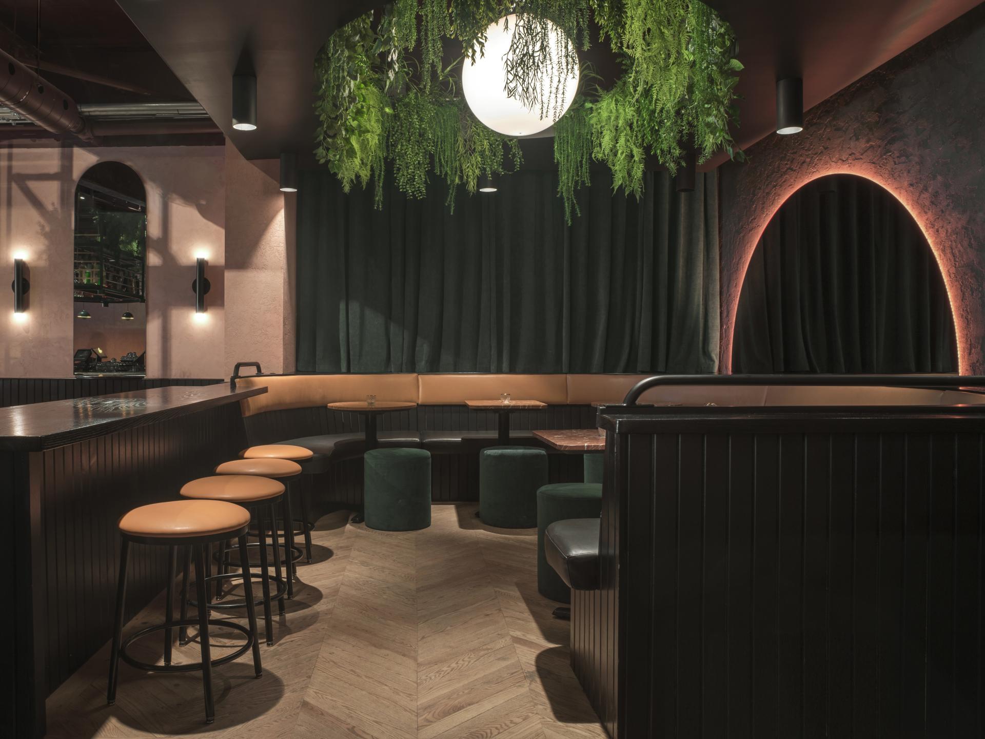 Tropical-themed restaurant interior featuring curved seating, greenery, and warm lighting in a Montreal eatery.