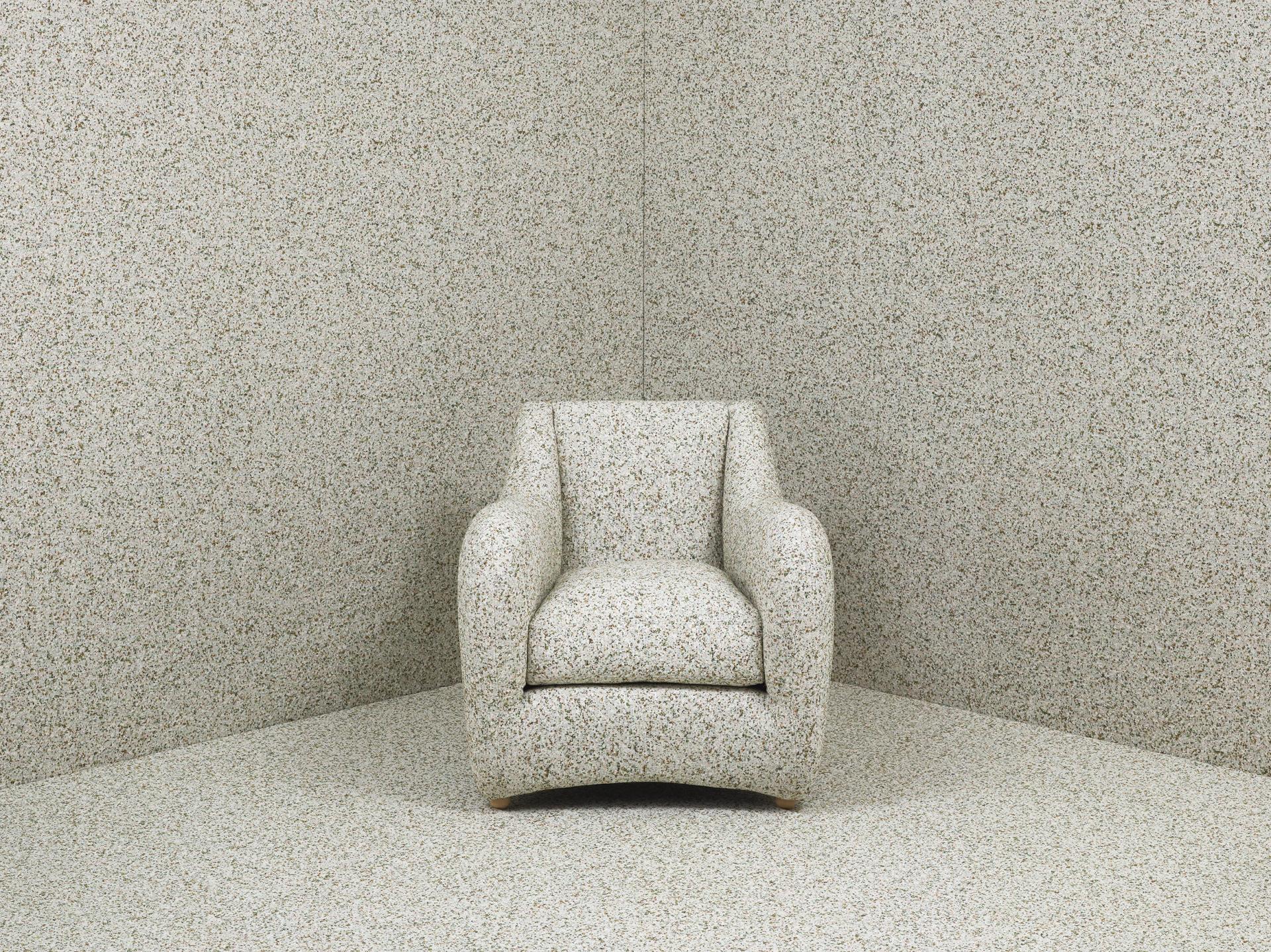 Matthew Hilton's Balzac armchair, upholstered in speckled fabric, showcased in a matching textured room setting.
