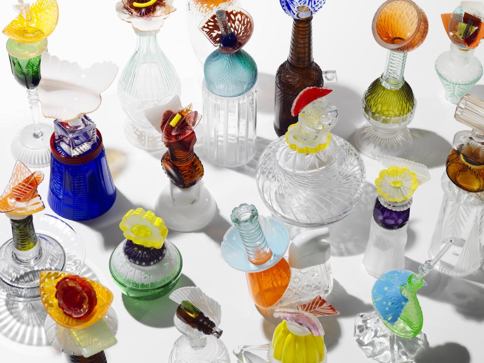 Colorful glass sculptures arranged artistically, showcasing creativity and innovation by UK-based experimental artists in the exhibition.