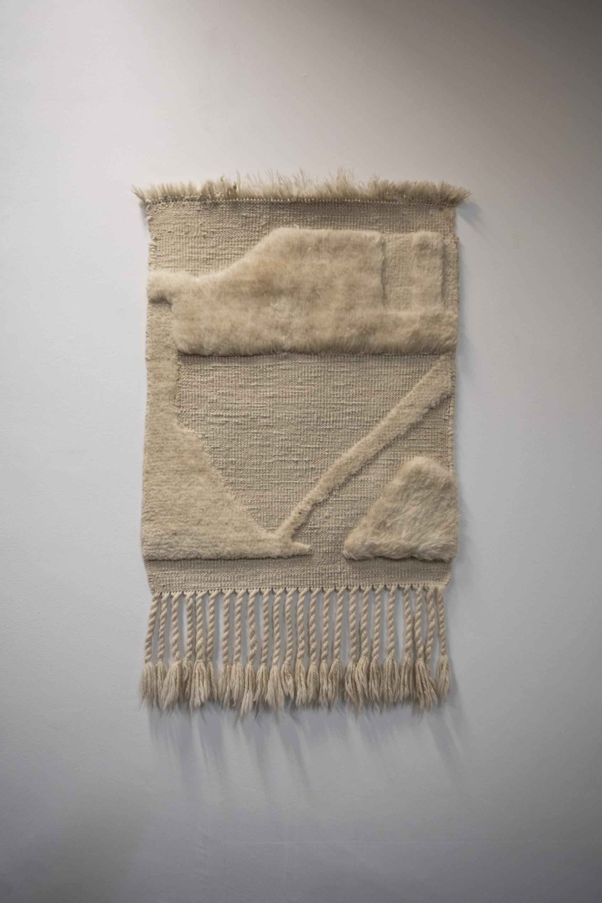 Textile artwork by Dharma Taylor featuring textured patterns and fringe, exploring themes of memory and narrative.