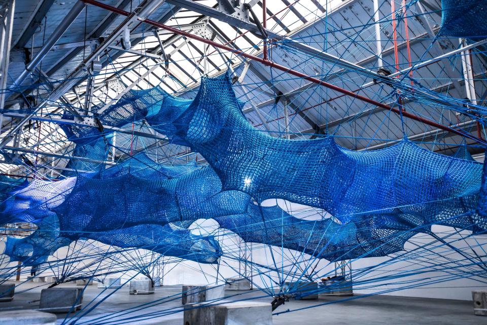 Immersive installation featuring intricate blue netting, part of Anya Hindmarch's Weave Project for London Fashion Week.