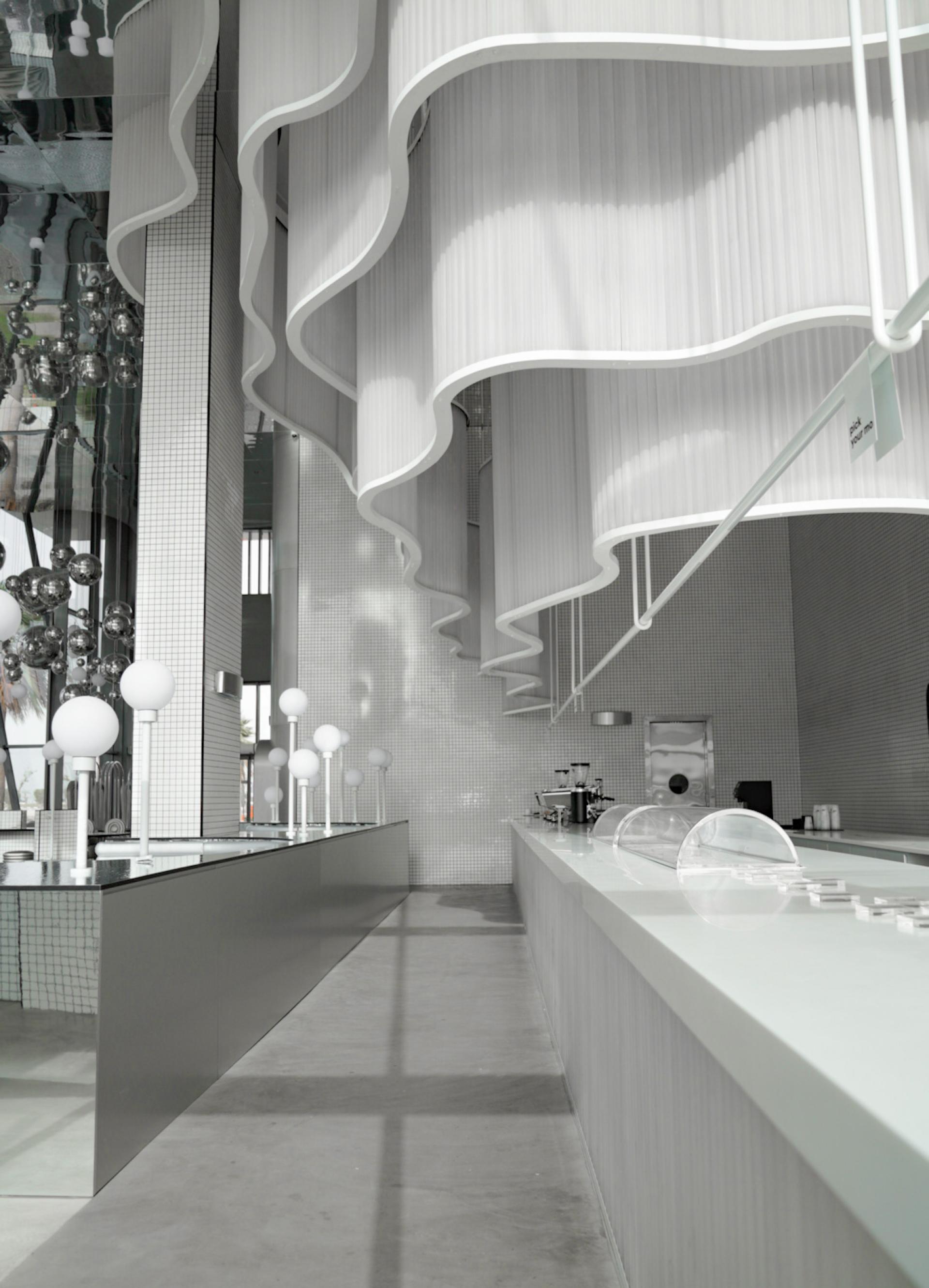 Modern interior design of MO bakehouse and espresso bar with wavy white accents and minimalist decor in Khobar.