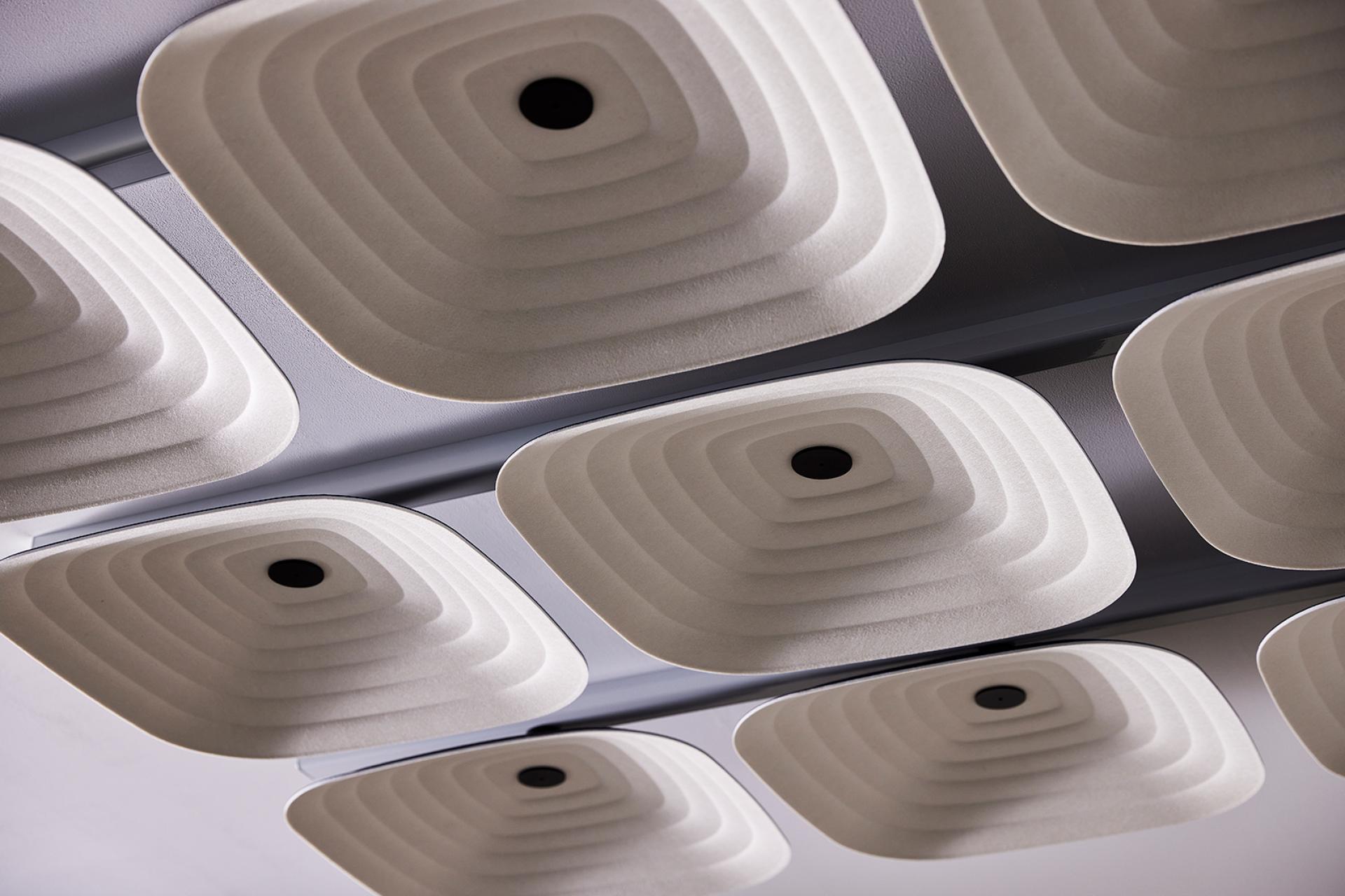 Ceiling panels in a modern workspace showcasing innovative acoustic design for enhanced sound quality in office environments.
