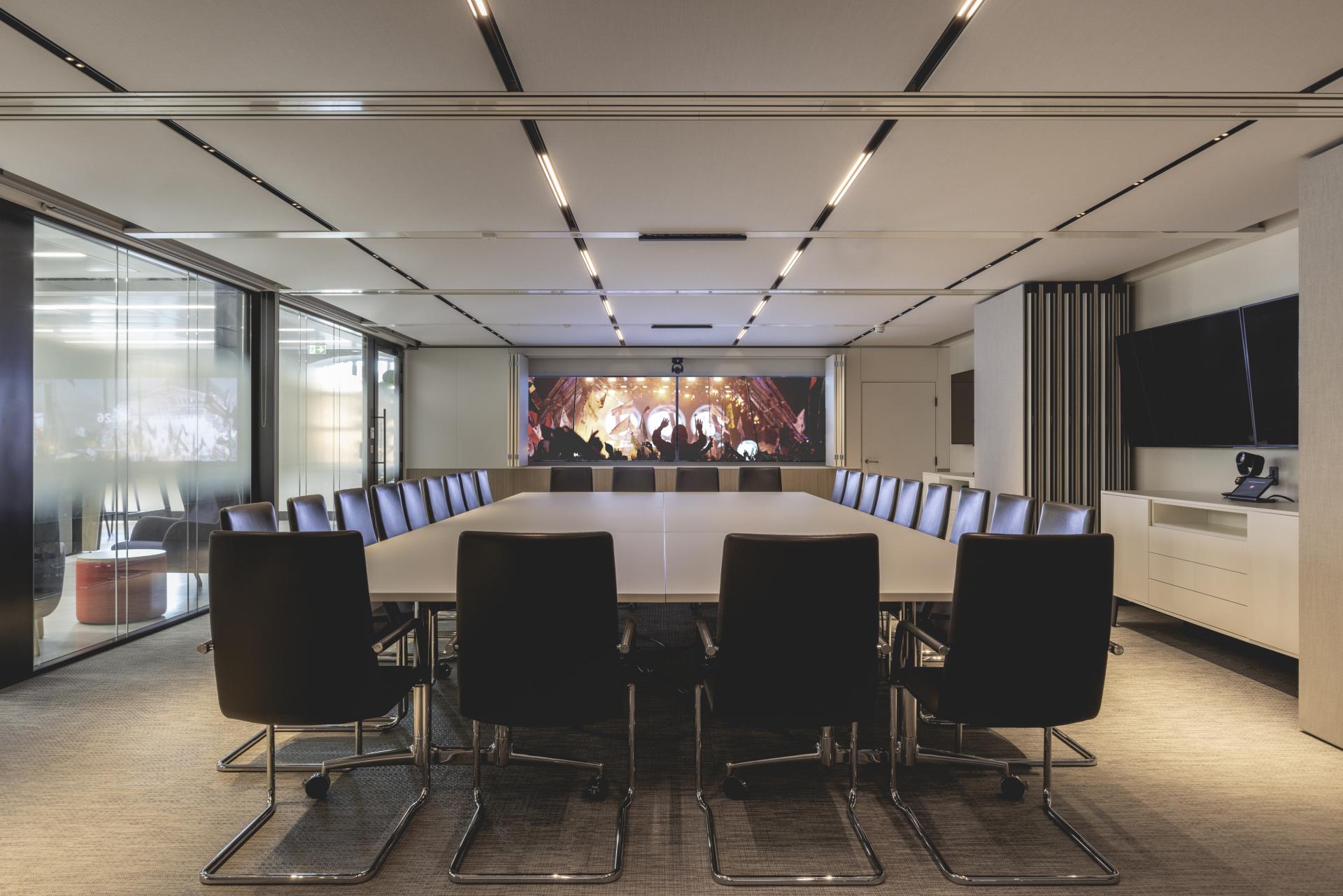Modern conference room featuring a large table and a vibrant digital display, designed for collaborative work at PRS for Music's HQ.