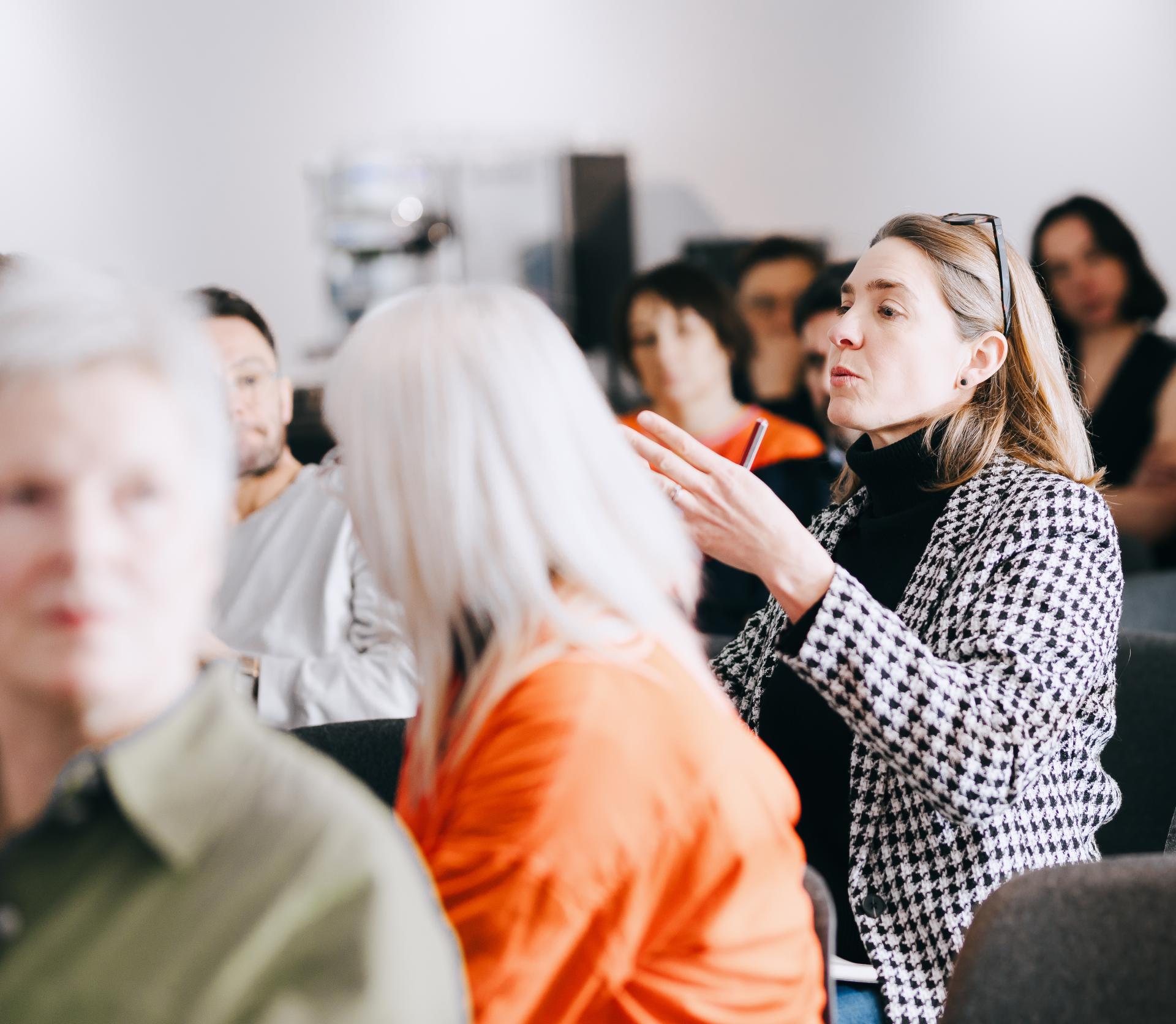 Audience engaged in discussion during a sustainable solutions seminar at the University of Glasgow, featuring Professor Jaime Toney.