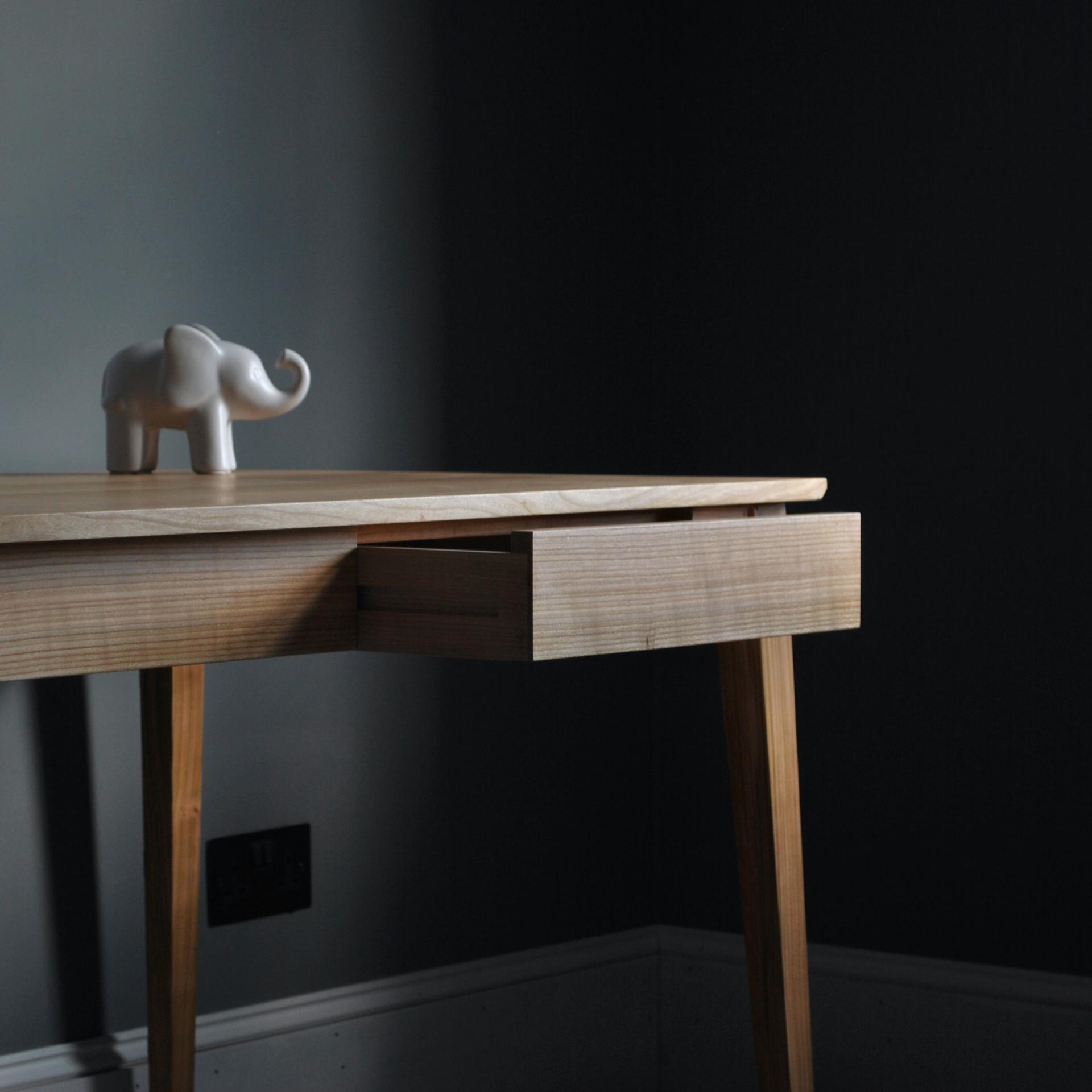 Contemporary wooden table featuring a playful elephant figurine, highlighting material sustainability and minimalist design.