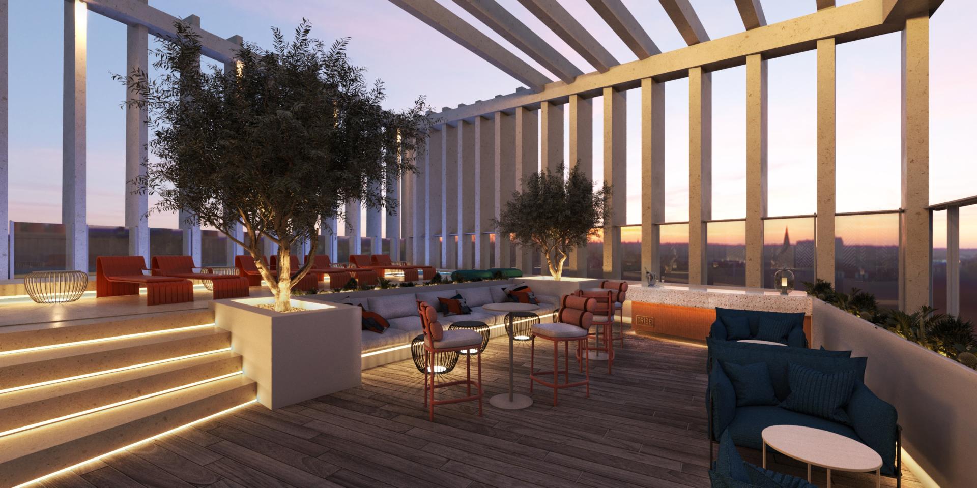 Rooftop lounge area of Tribe hotel featuring modern seating, greenery, and sunset views, designed by SpaceInvader.