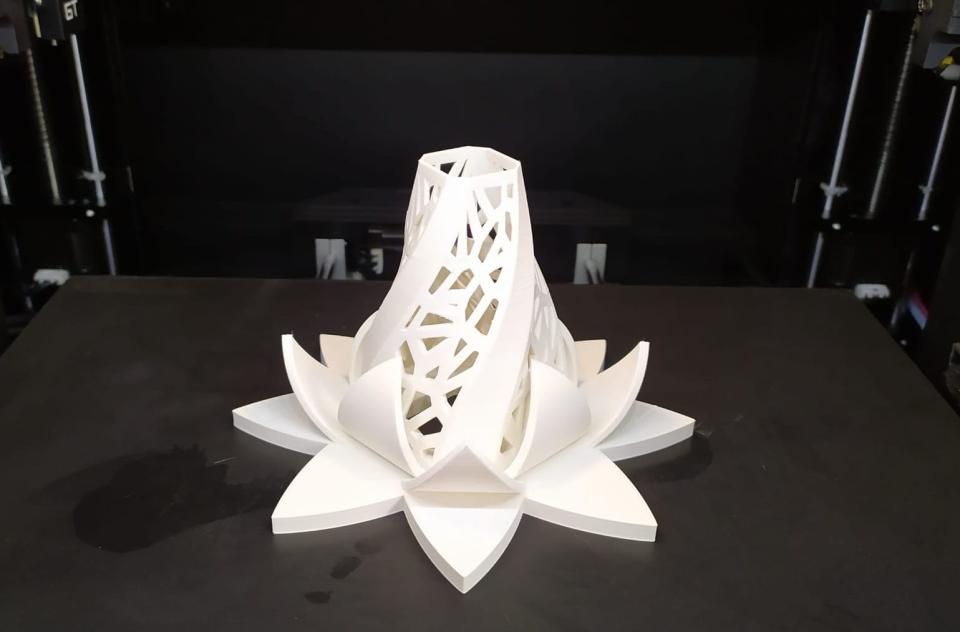 3D printed sculpture made from post-consumer plastic, showcasing intricate geometric patterns and a floral design.