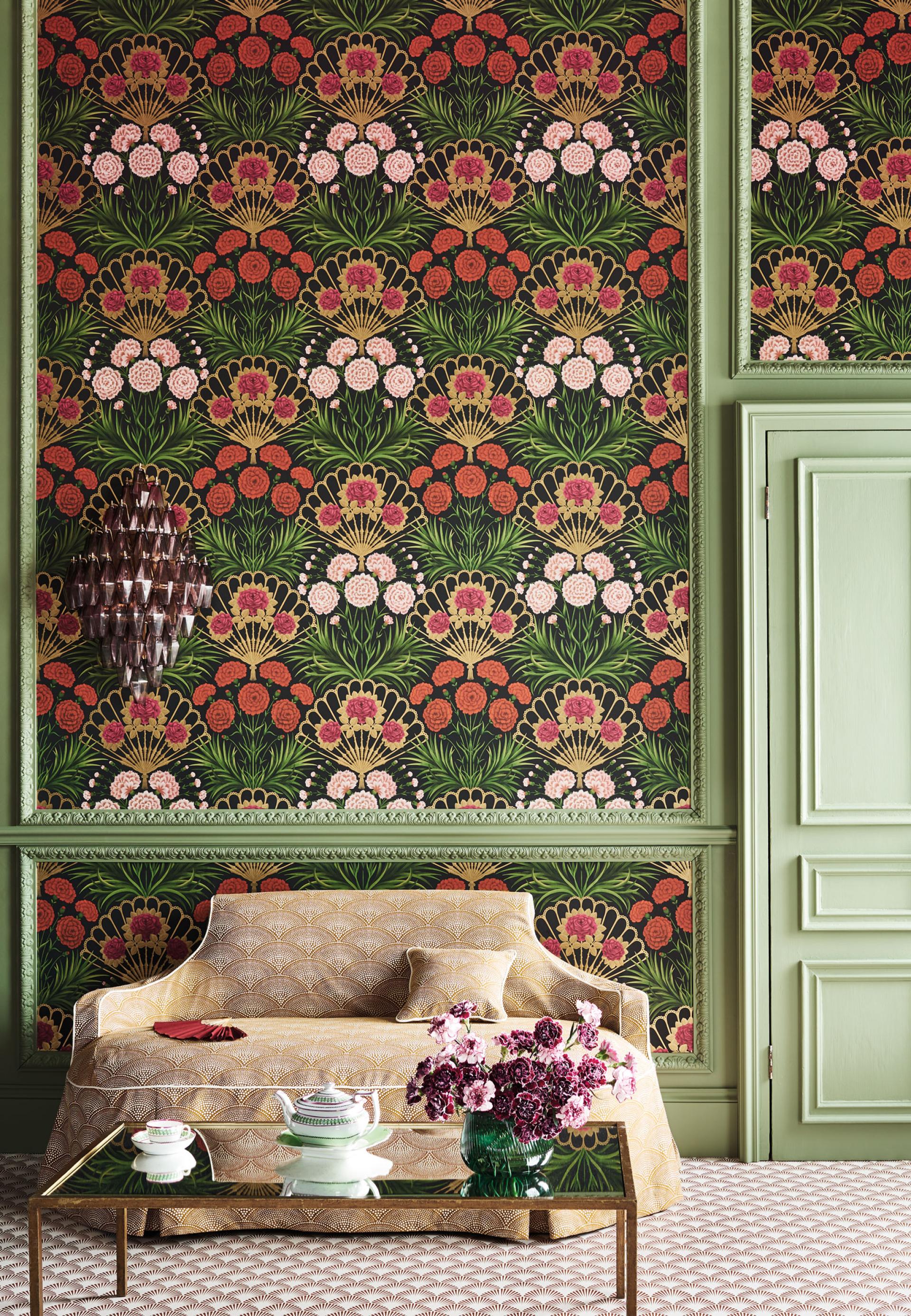 Colorful floral wallpaper in green and red tones adorns a stylish room with a vintage sofa and decorative accents.