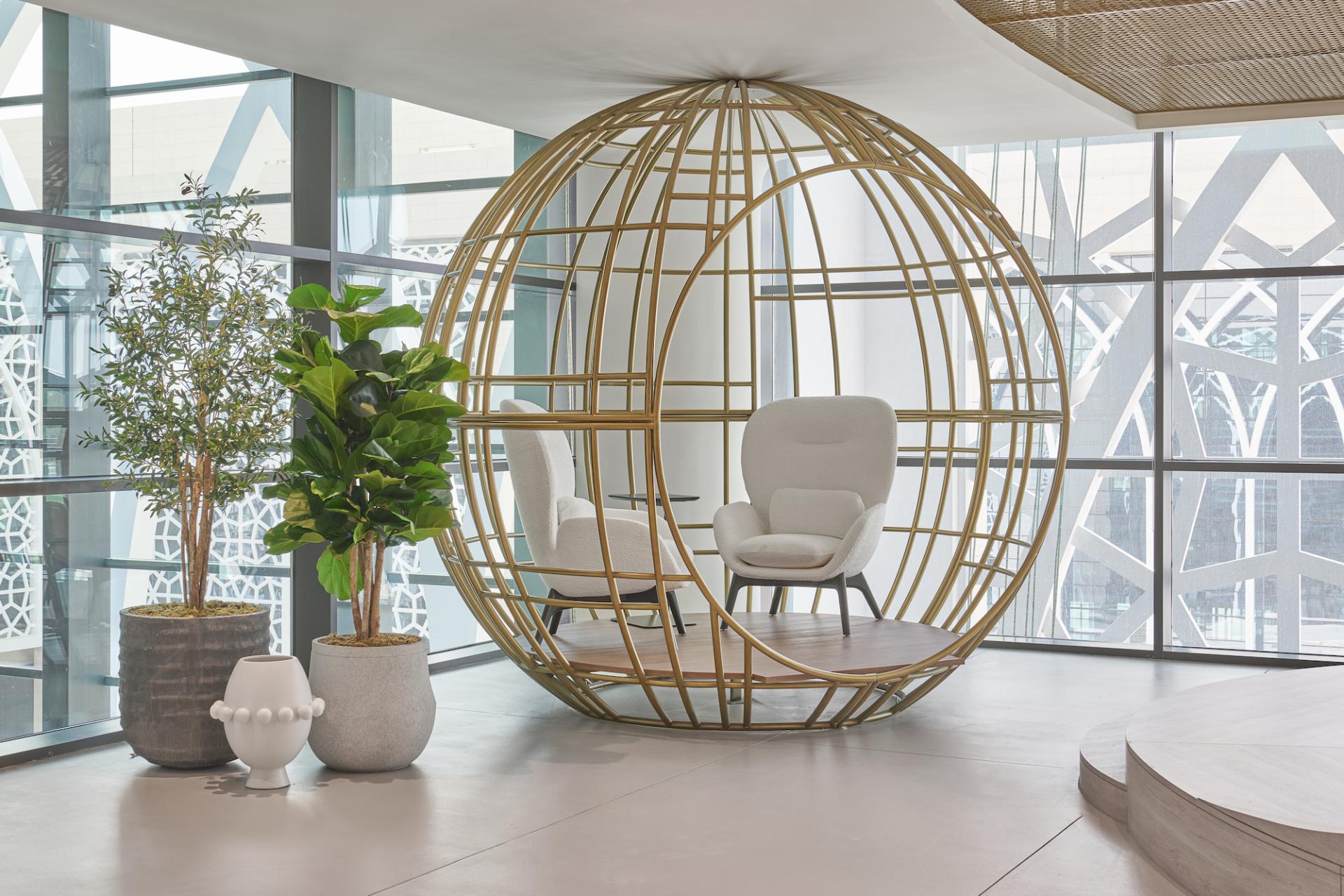 A modern spherical seating area surrounded by plants, designed for the Sharjah Entrepreneurship Center's creative workspace.