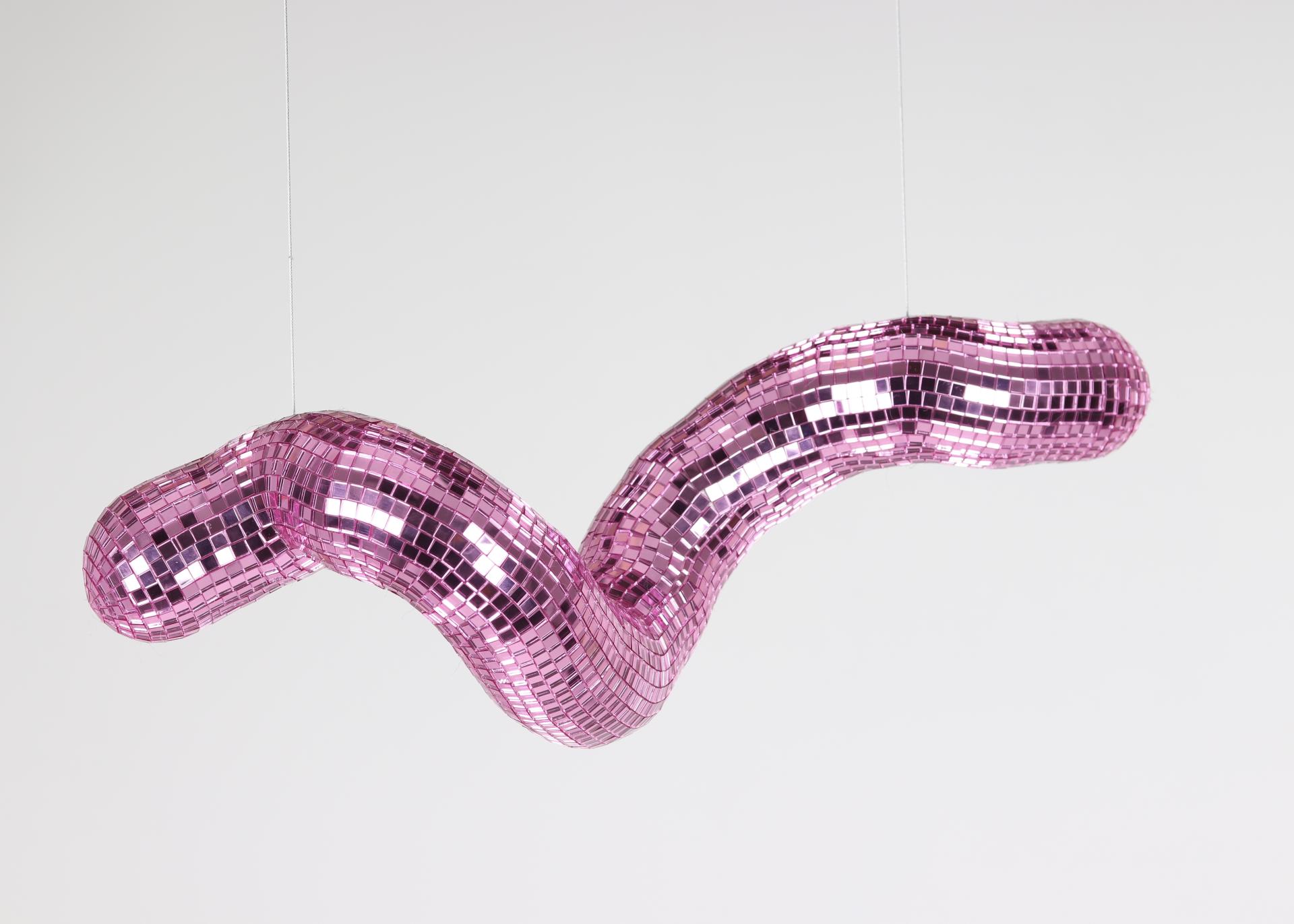 Sculptural pink disco piece with reflective tiles, showcasing vibrant colors and playful design from Dutch Design Week 2023.