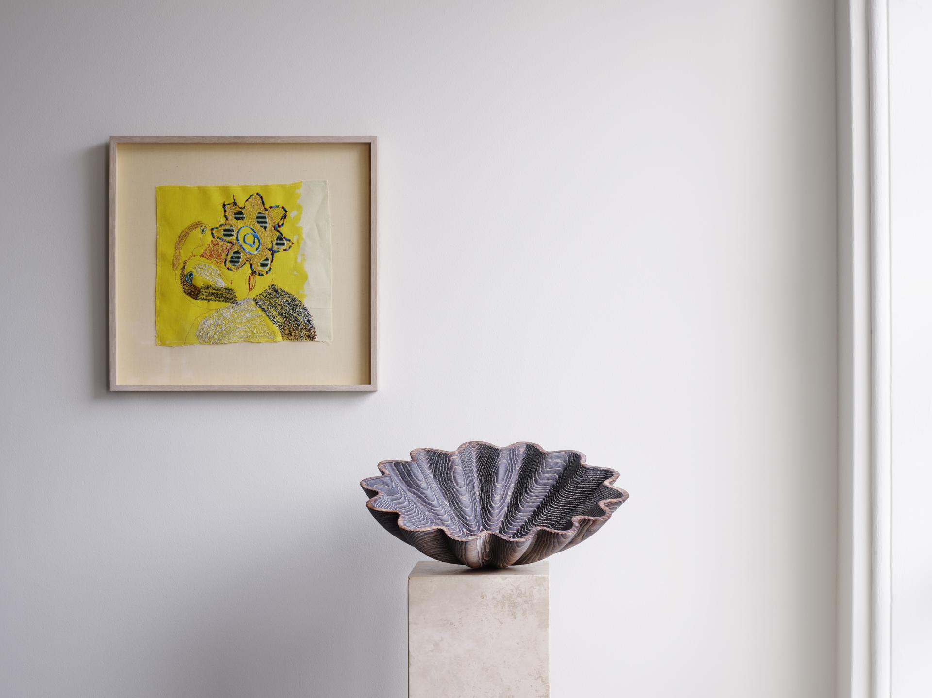 Colorful framed artwork and a decorative ceramic bowl displayed in a modern gallery setting at Somerset House.