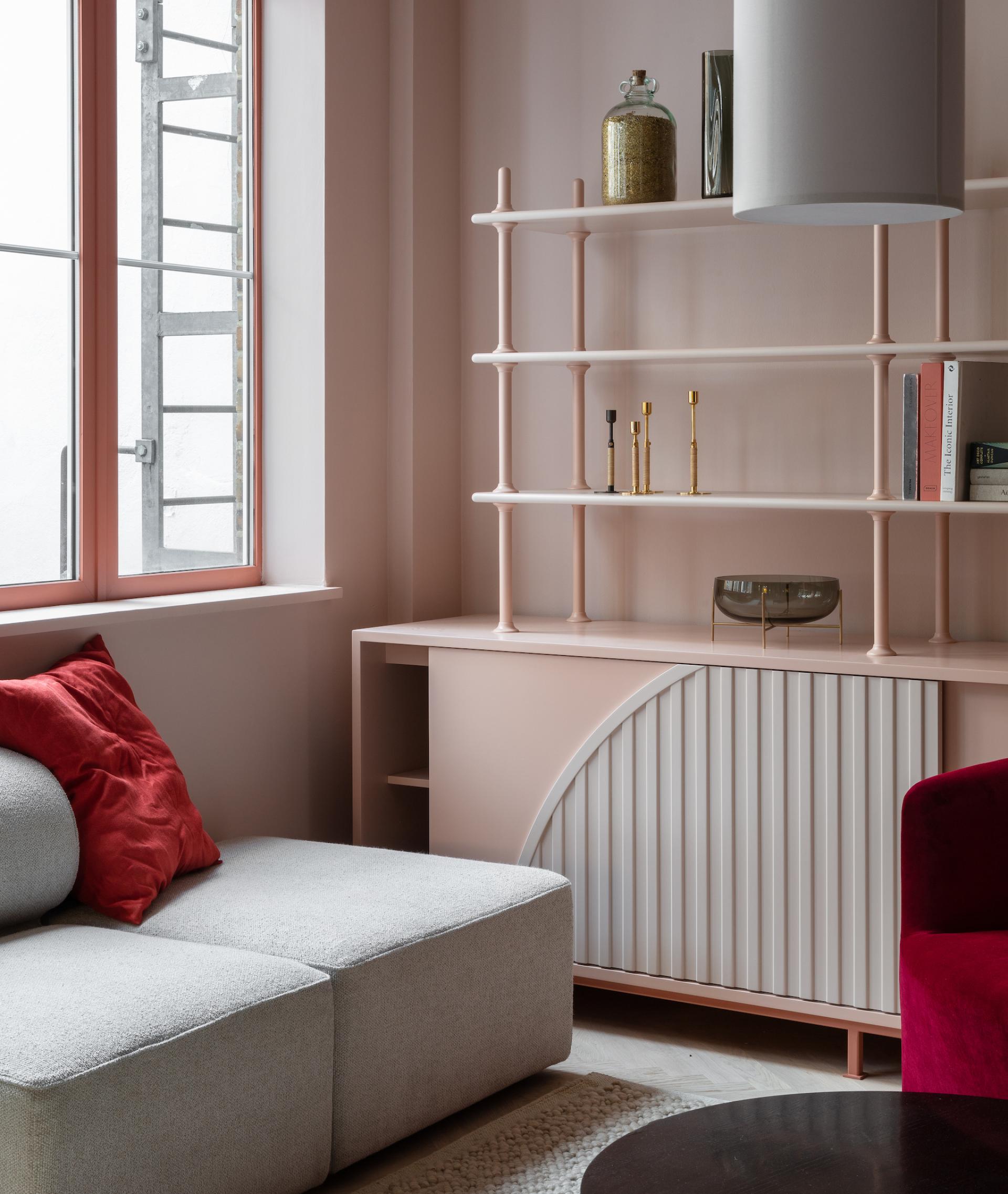 Cozy interior featuring a modern couch, pink shelving unit, and decorative accents in Holloway Li's new Clerkenwell showroom.