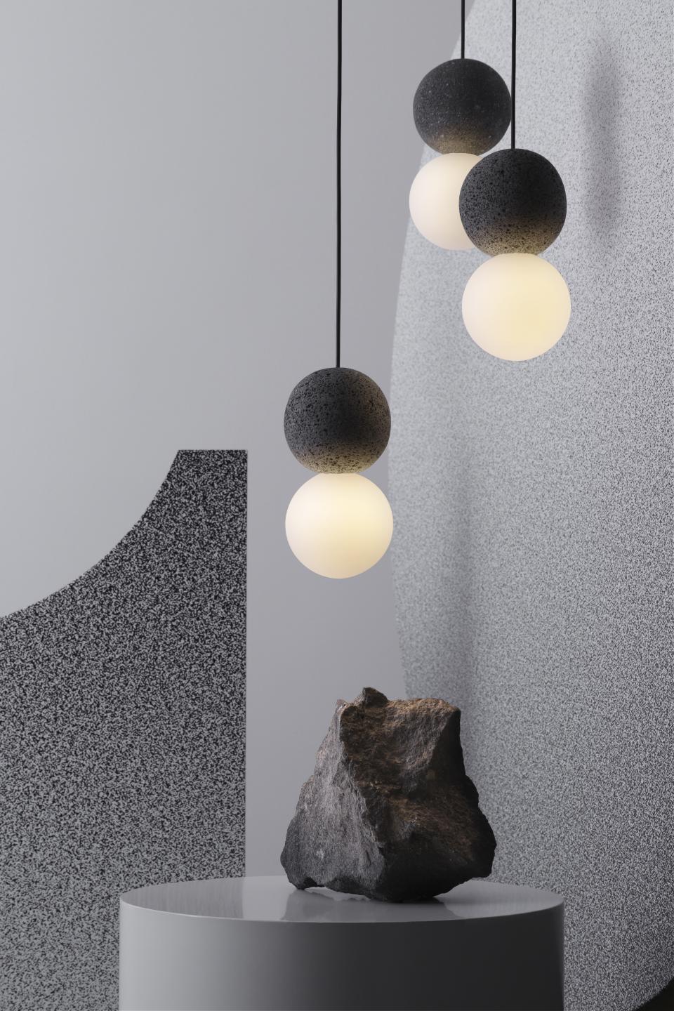 Hanging Origo lighting fixtures made from volcanic rock and glass, highlighting studio davidpompa's innovative design.