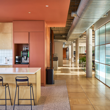Modern kitchen area with wooden cabinetry and sleek furnishings, highlighting sustainable design in Joseph Joseph's London workspace.