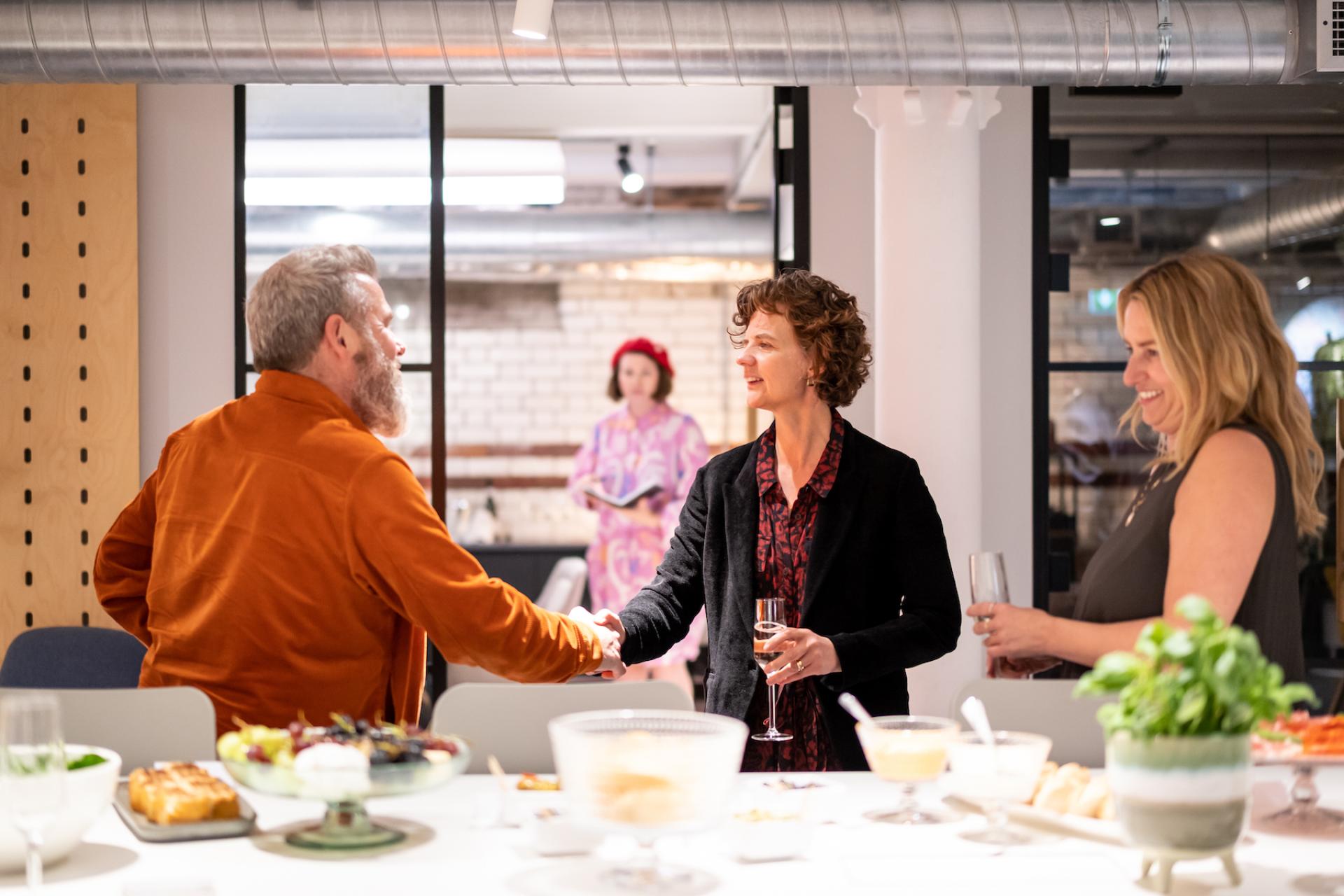 Professionals networking over refreshments in a modern, educational gathering space, showcasing collaboration in the future of education.