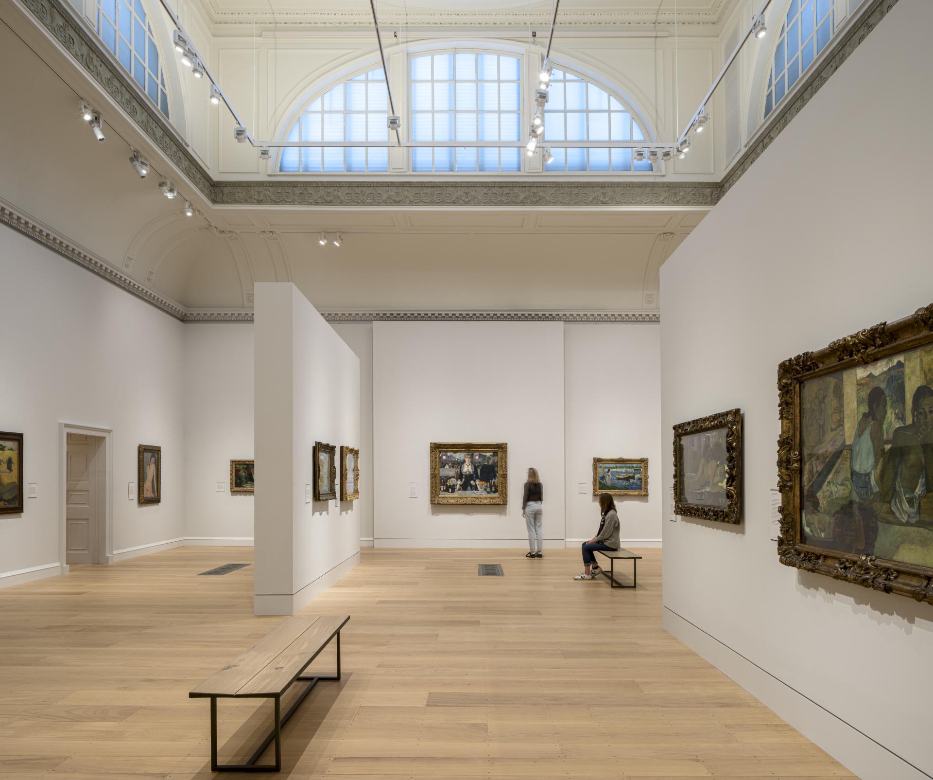Visitors explore the redesigned interior of The Courtauld Gallery, showcasing a modern exhibition space and artwork.