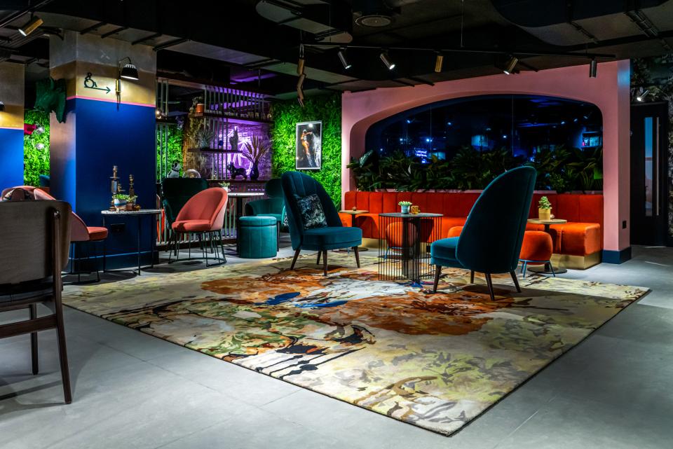 Vibrant interior design featuring colorful seating, bold artworks, and lush greenery at Manchester's Qbic hotel by BOBO1325.