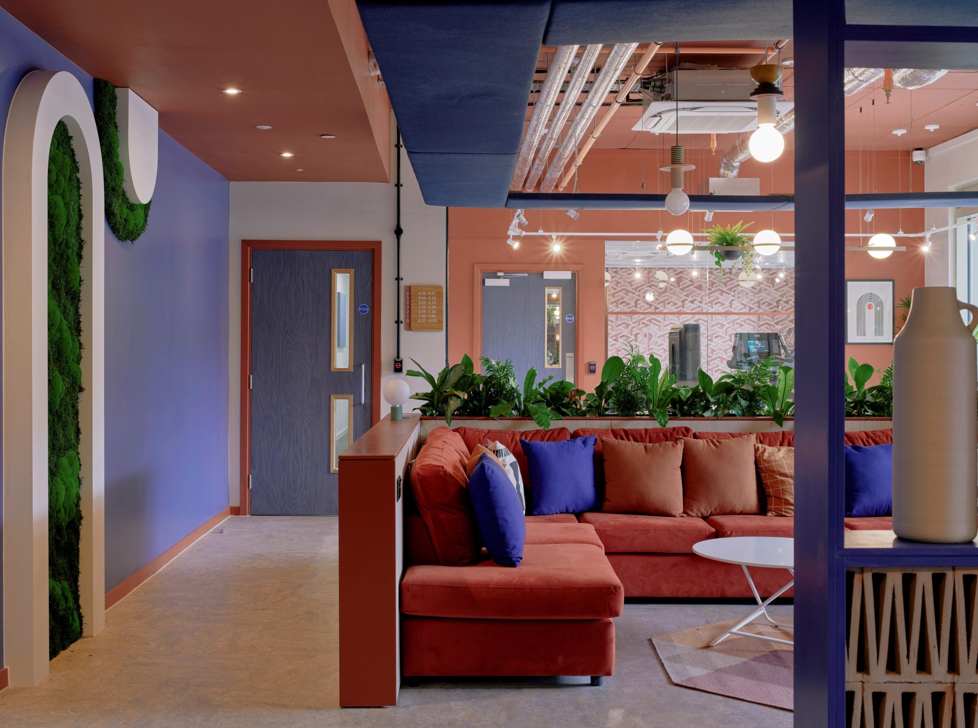 Modern open-concept interior of Enso, featuring vibrant furnishings and greenery, reflecting Colchester's historical charm and community focus.