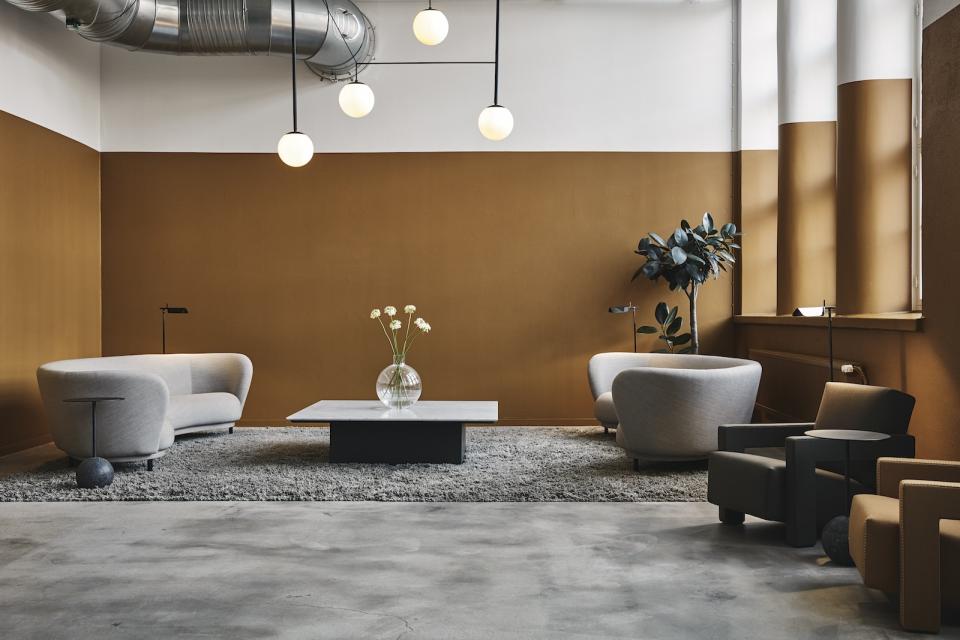 Stylish interior of a refurbished bread factory featuring modern furniture, a coffee table, and decorative plants.