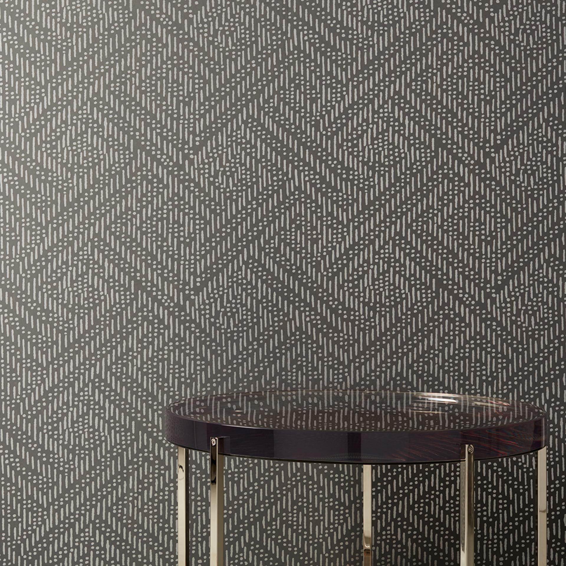 Modern wallcovering featuring a geometric pattern in shades of gray, paired with a sleek round table.
