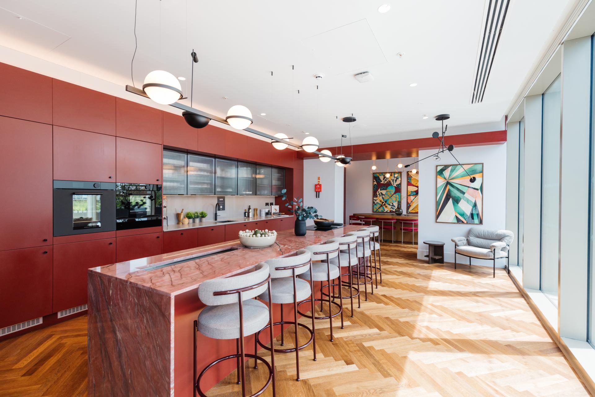 Modern kitchen design featuring a spacious island, stylish bar stools, and vibrant artwork, highlighting rental lifestyle and design trends.