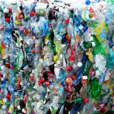 A colorful jumble of plastic bottles and containers representing the challenge of plastic waste in bioplastics discussions.