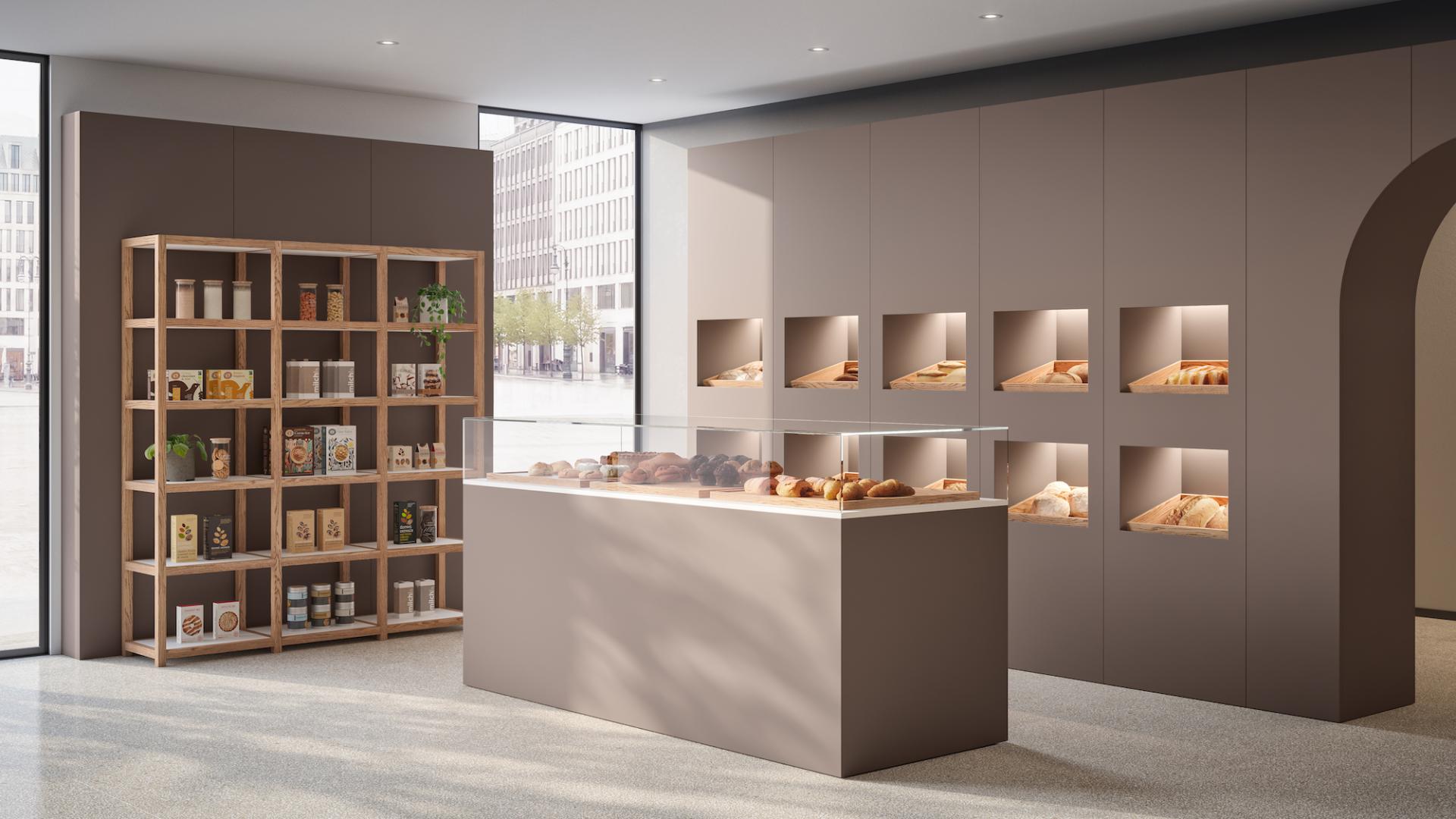 Modern bakery interior showcasing a display case of baked goods, wooden shelving with products, and neutral tones.