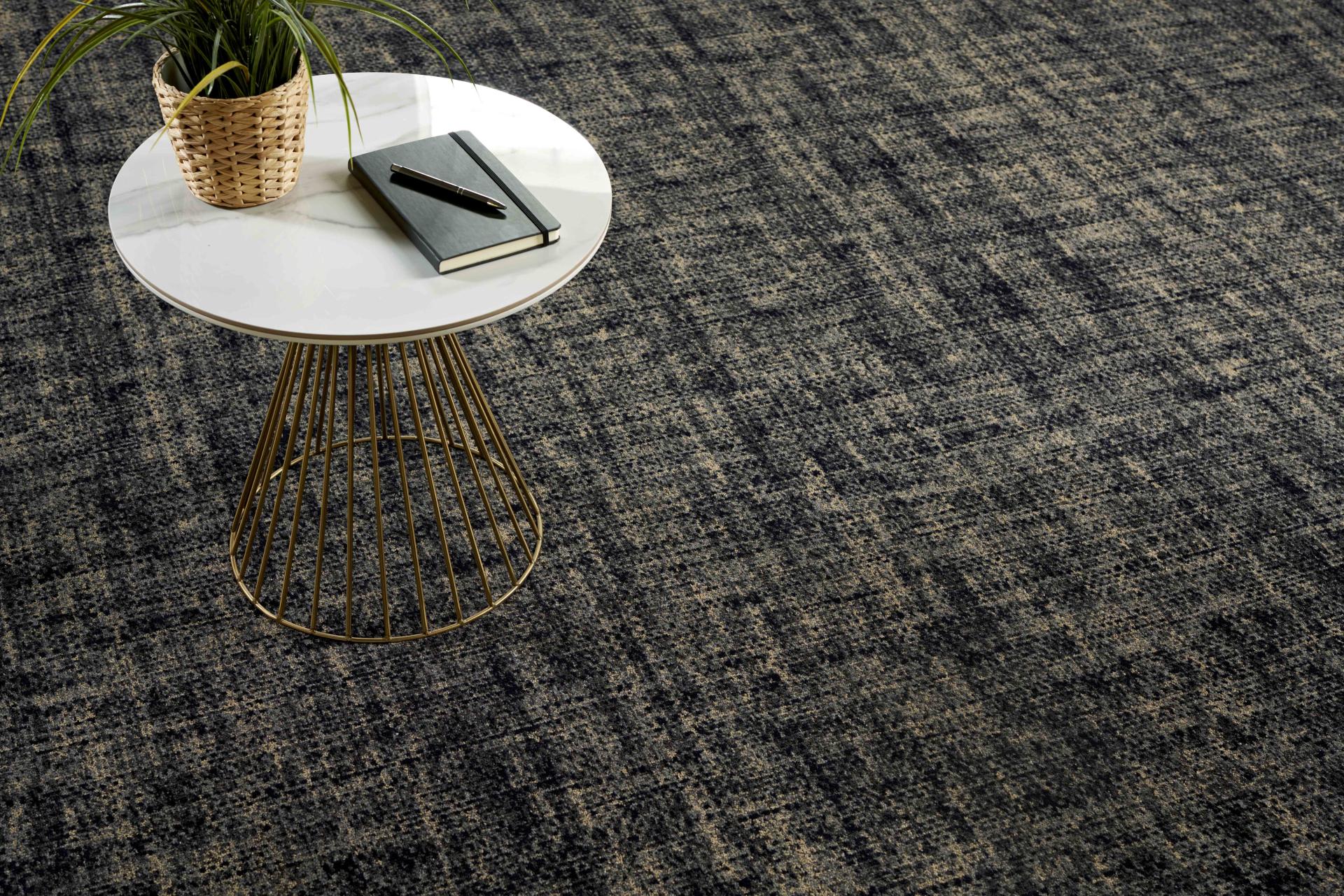 Stylish coffee table with a notebook and plant over Newhey Carpets' Patina 2.0 flooring collection.