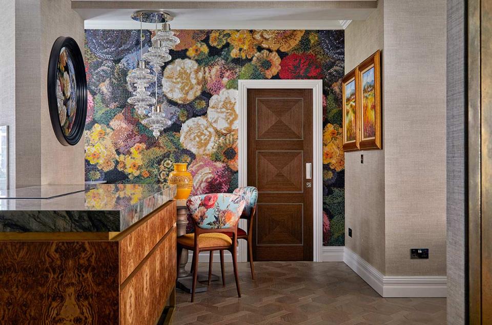 Luxurious Knightsbridge apartment entry featuring floral mosaic wallpaper, stylish chandelier, and decorative furnishings inspired by Van Gogh.