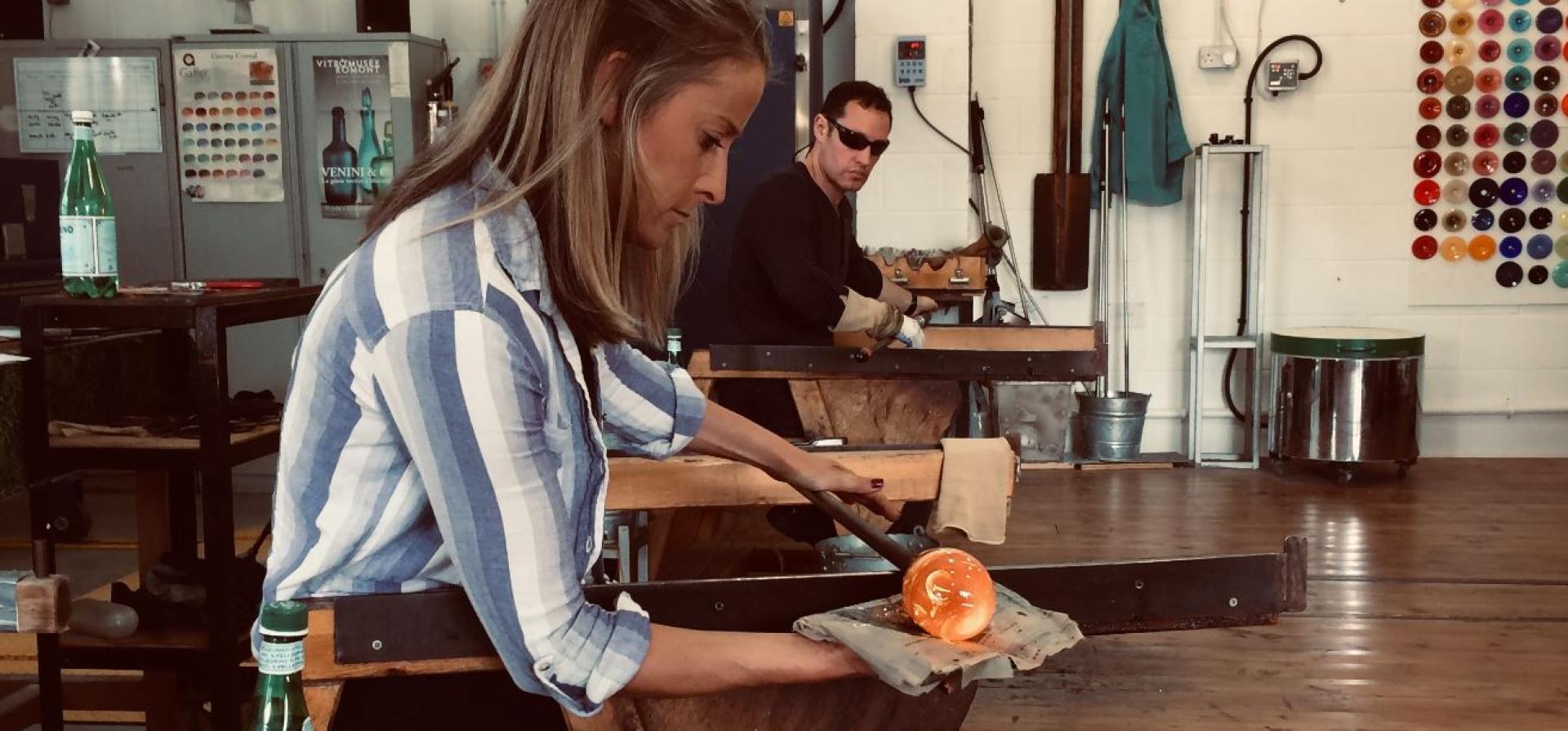 Award-winning designer Nicola Schellander shapes molten glass in a studio, highlighting the revival of the British crystal industry.