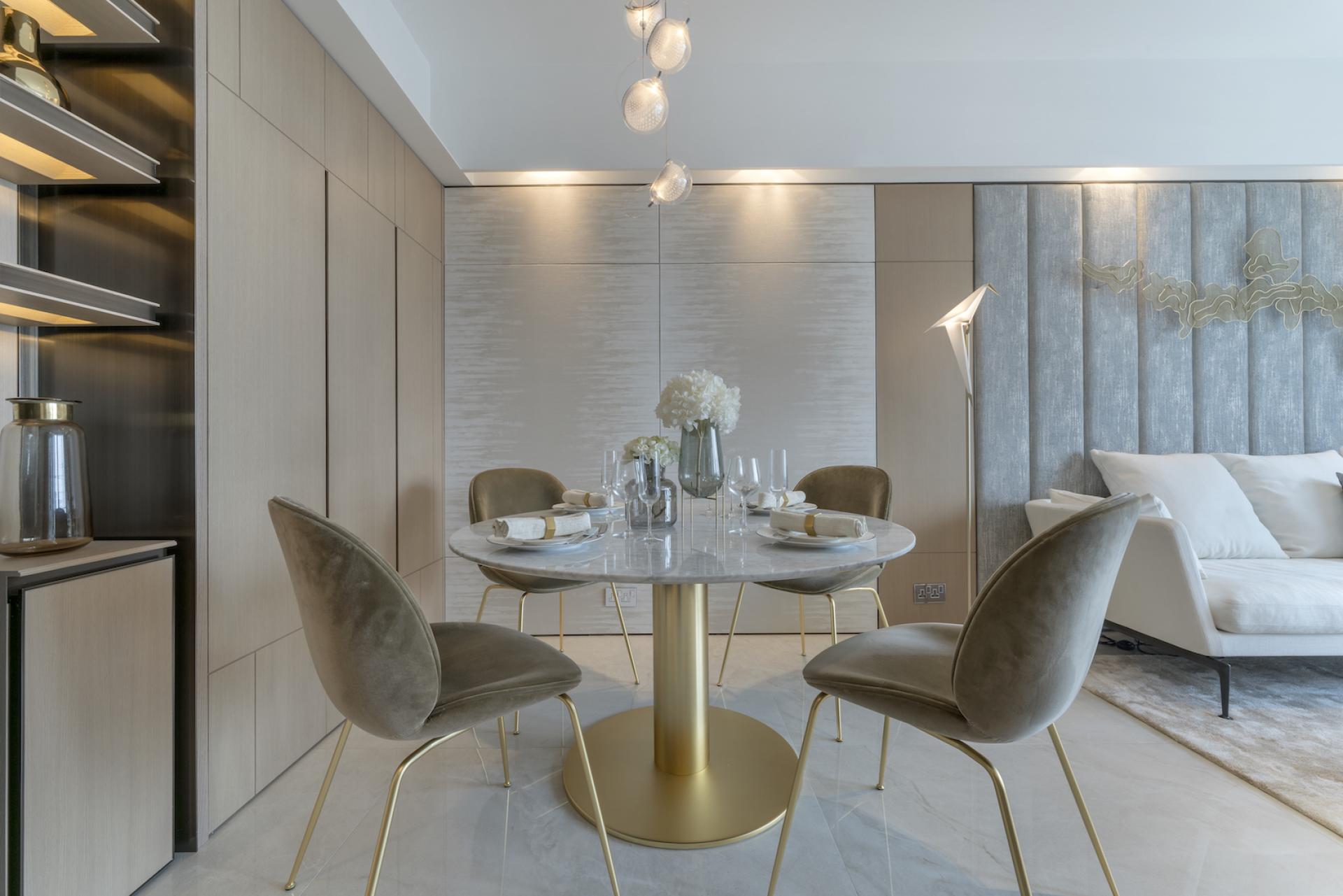 Elegant dining area in a Hong Kong apartment, featuring a round marble table, stylish chairs, and modern decor.