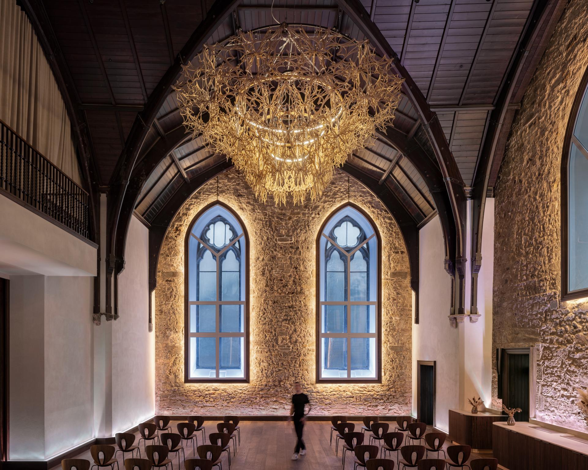 Modern 3D printed chandelier in a historic space, showcasing innovative design and architecture in contemporary interiors.