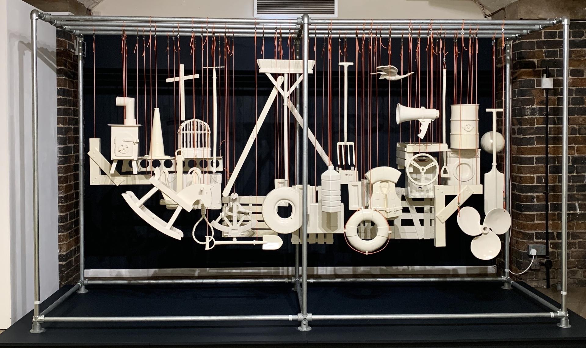 Suspended white sculptures of various objects, showcasing contemporary craft in the Collect 2025 exhibition at Somerset House.