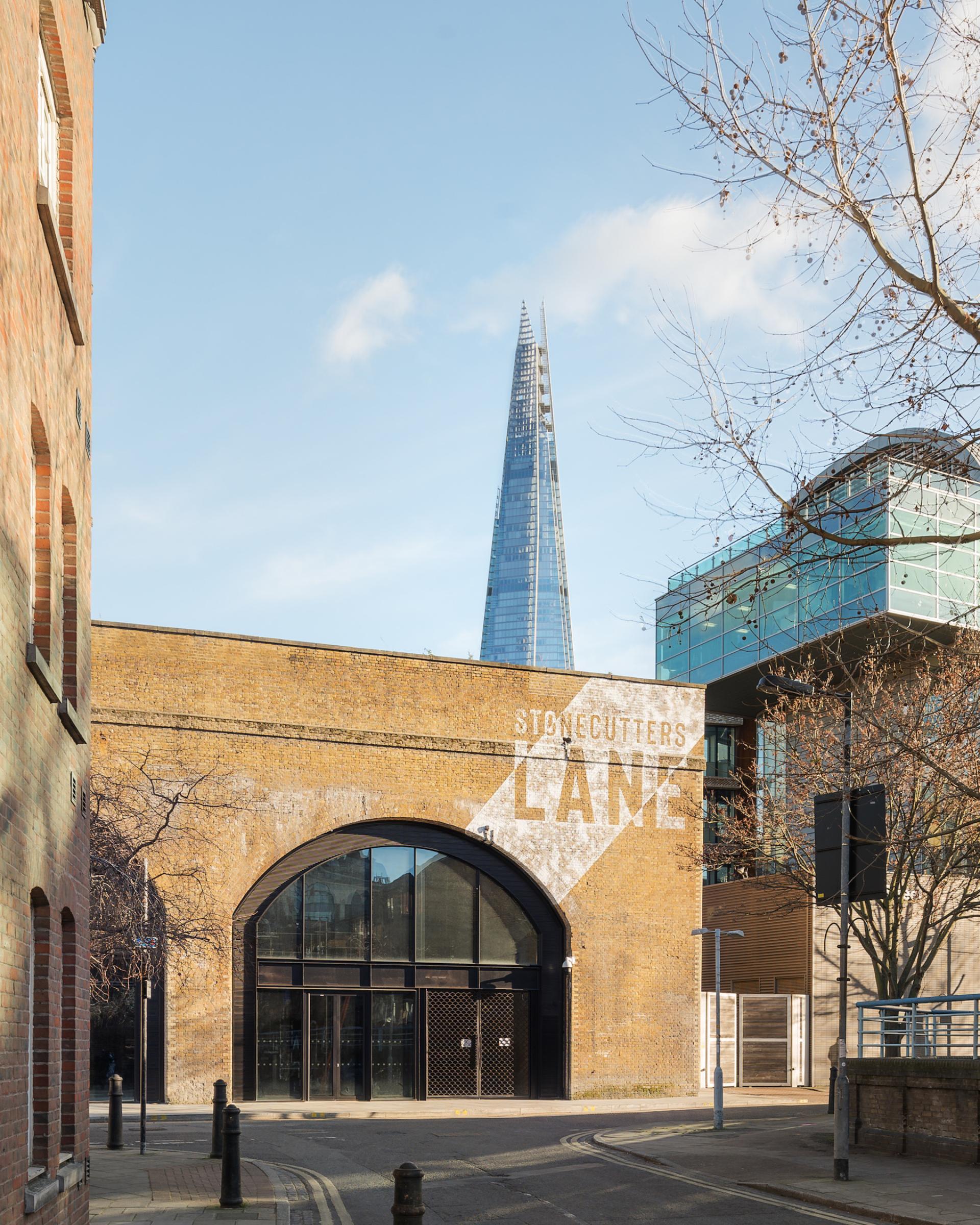 Historic building entrance on Stonecutters Lane with The Shard in the background at Borough Yards, London.