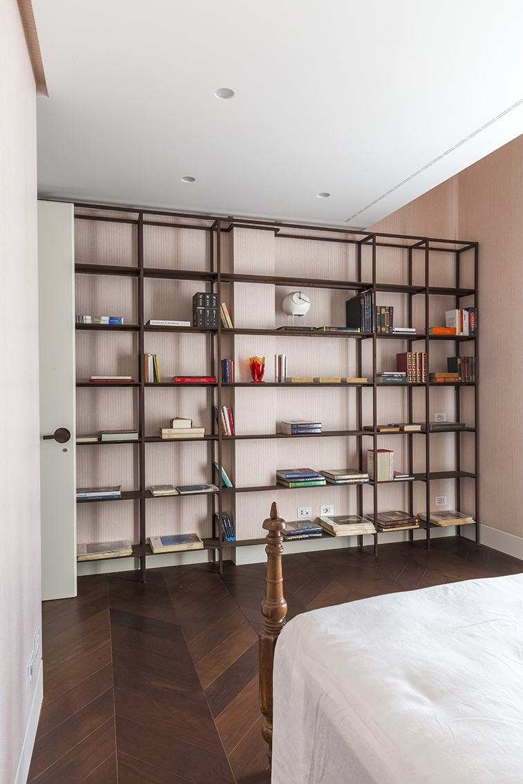 Guest bedroom. Wall bookcase with wengé wood veneer custom designed by Alvisi Kirimoto; wallpaper by Metamorphosi; ceiling lights Le Perroquet by IGuzzini; Pendule clock by Papier à étres for Serax; Fish vase design Gaetano Pesce. ©Serena Eller Vainicher