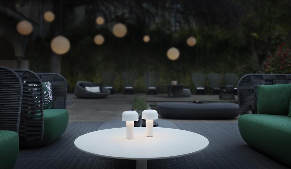 Portable outdoor lighting on a coffee table in a stylish garden seating area, enhancing the ambiance for outdoor living.
