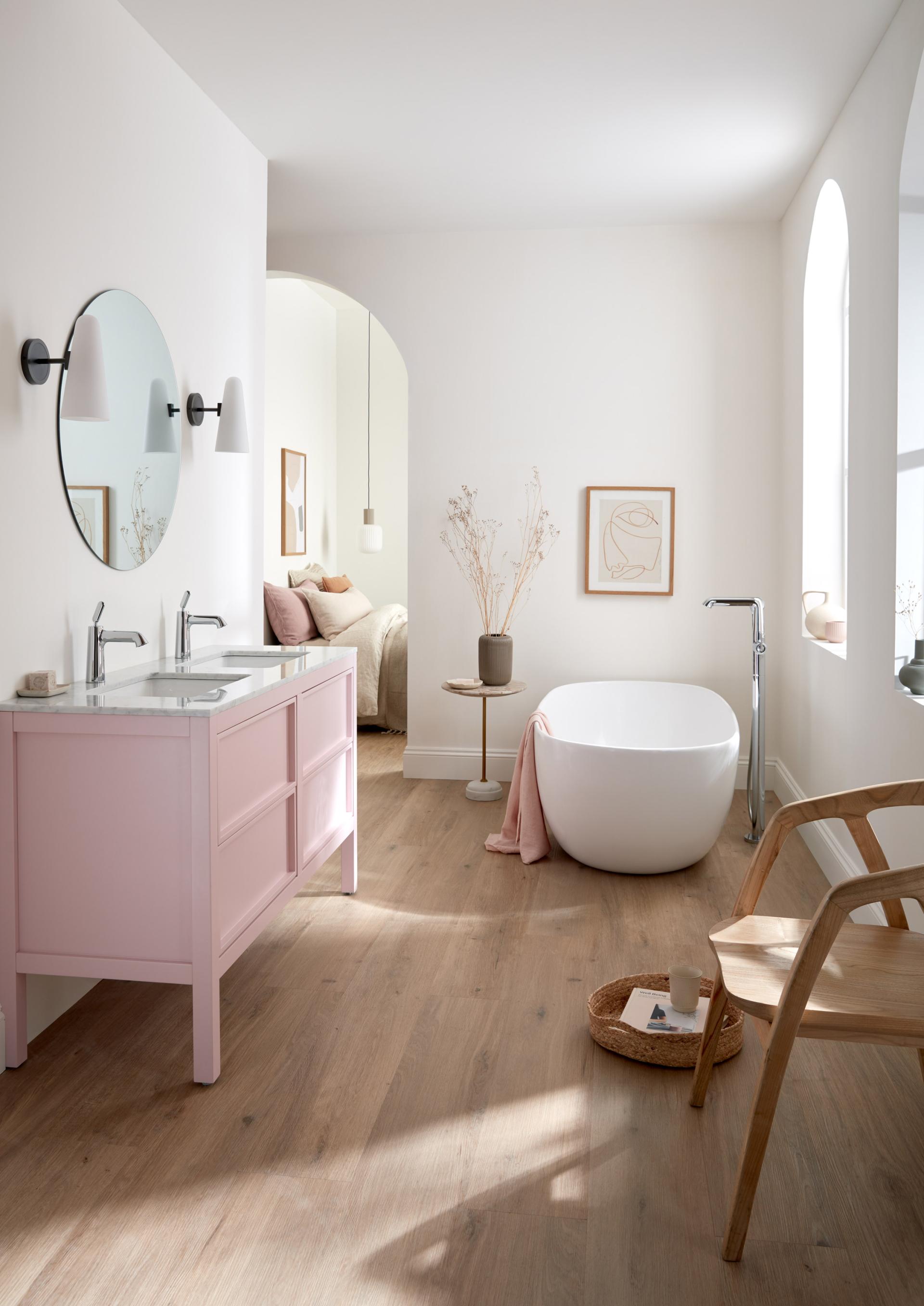 Elegant bathroom design featuring a pink vanity, freestanding bathtub, and modern decor by VADO and Conran and Partners.