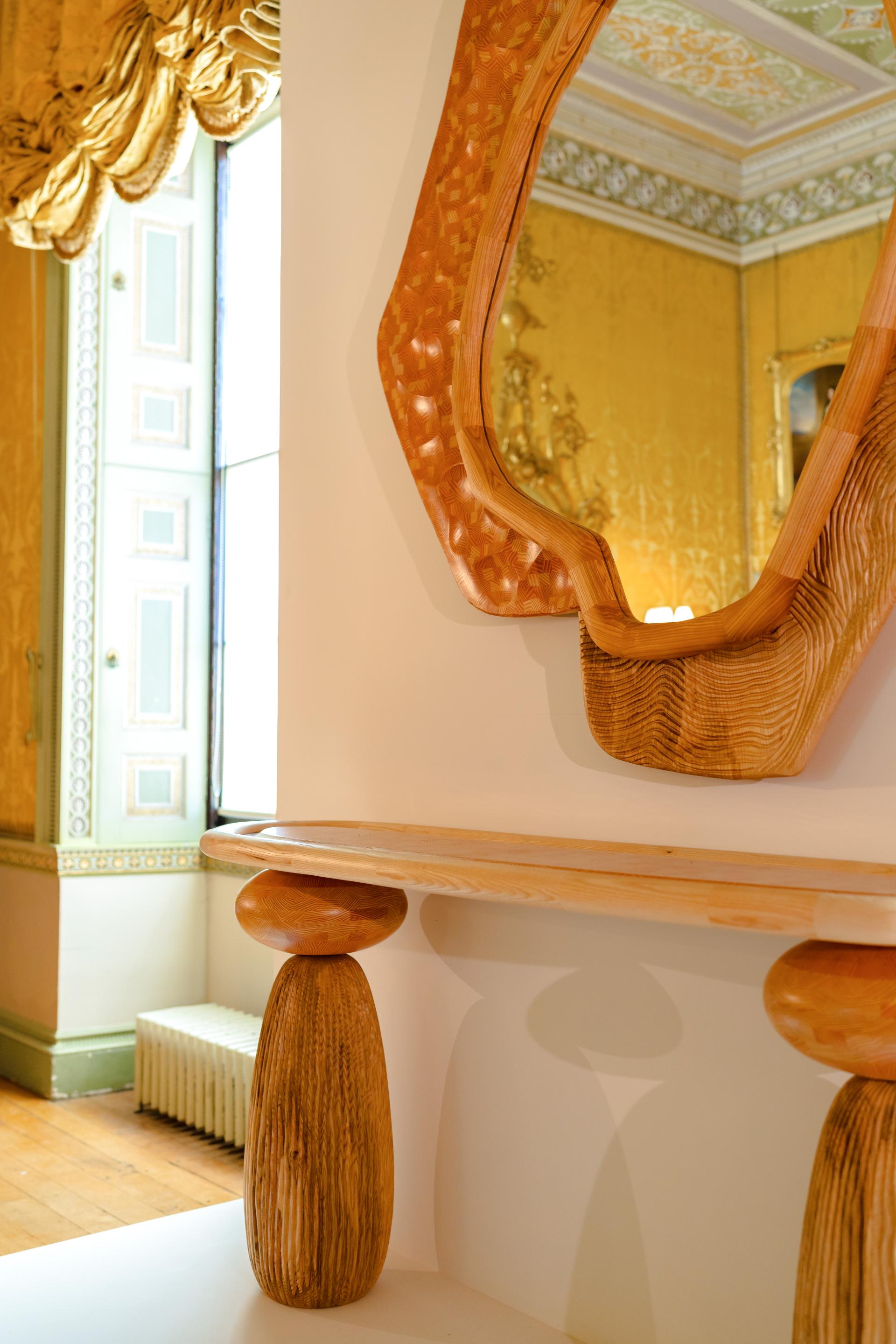 Stylish wooden mirror above a handcrafted console table, showcasing Jan Hendzel's unique expressive furniture design.