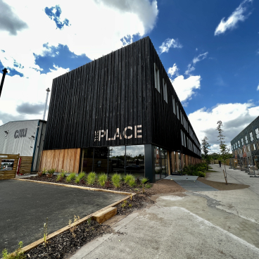Modern net zero carbon workspace in Leeds, showcasing sustainable architecture with a wooden facade and landscaped surroundings.