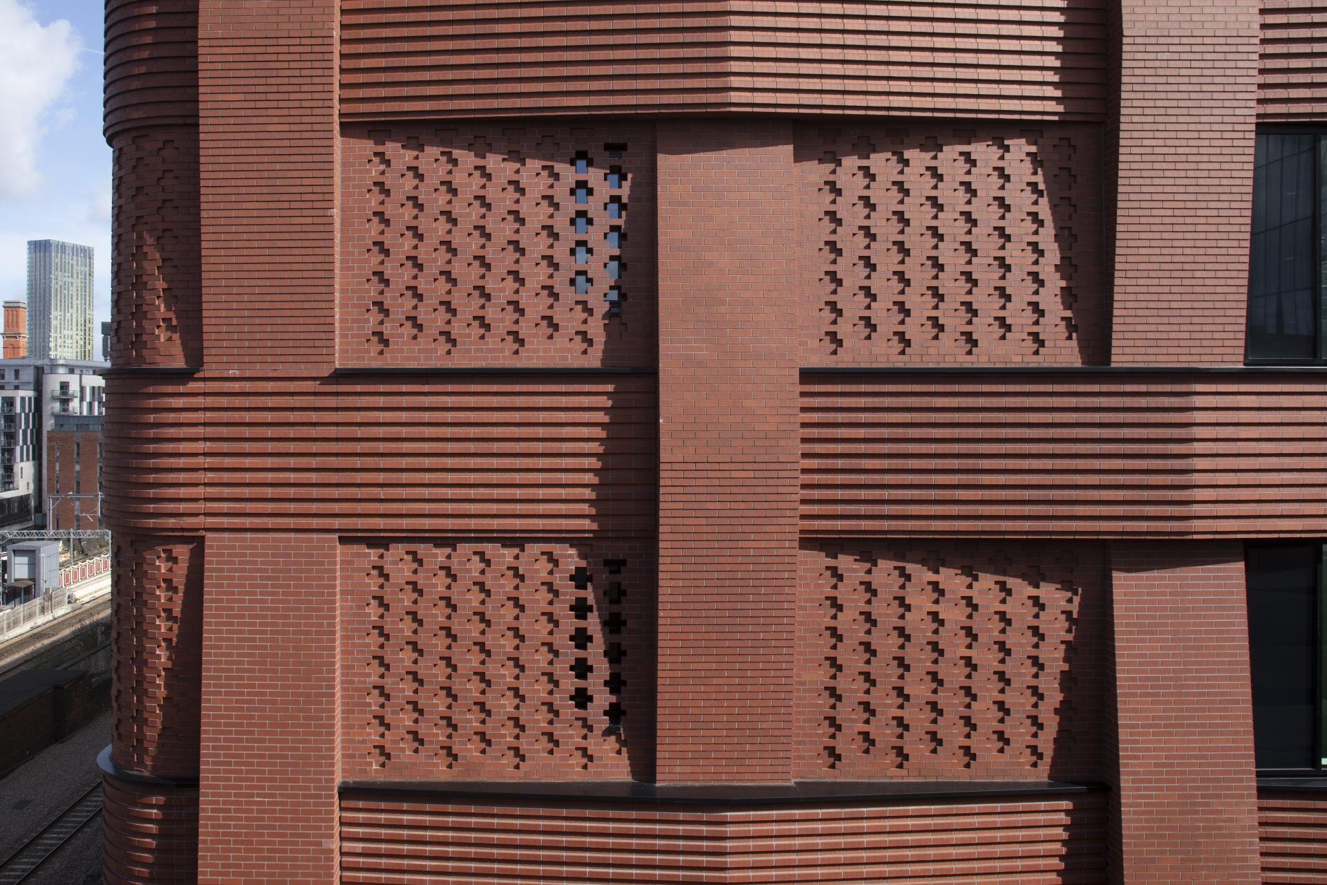 Architectural brick wall featuring geometric patterns and textures, showcasing innovative surface design at Surface Design Show 2023.