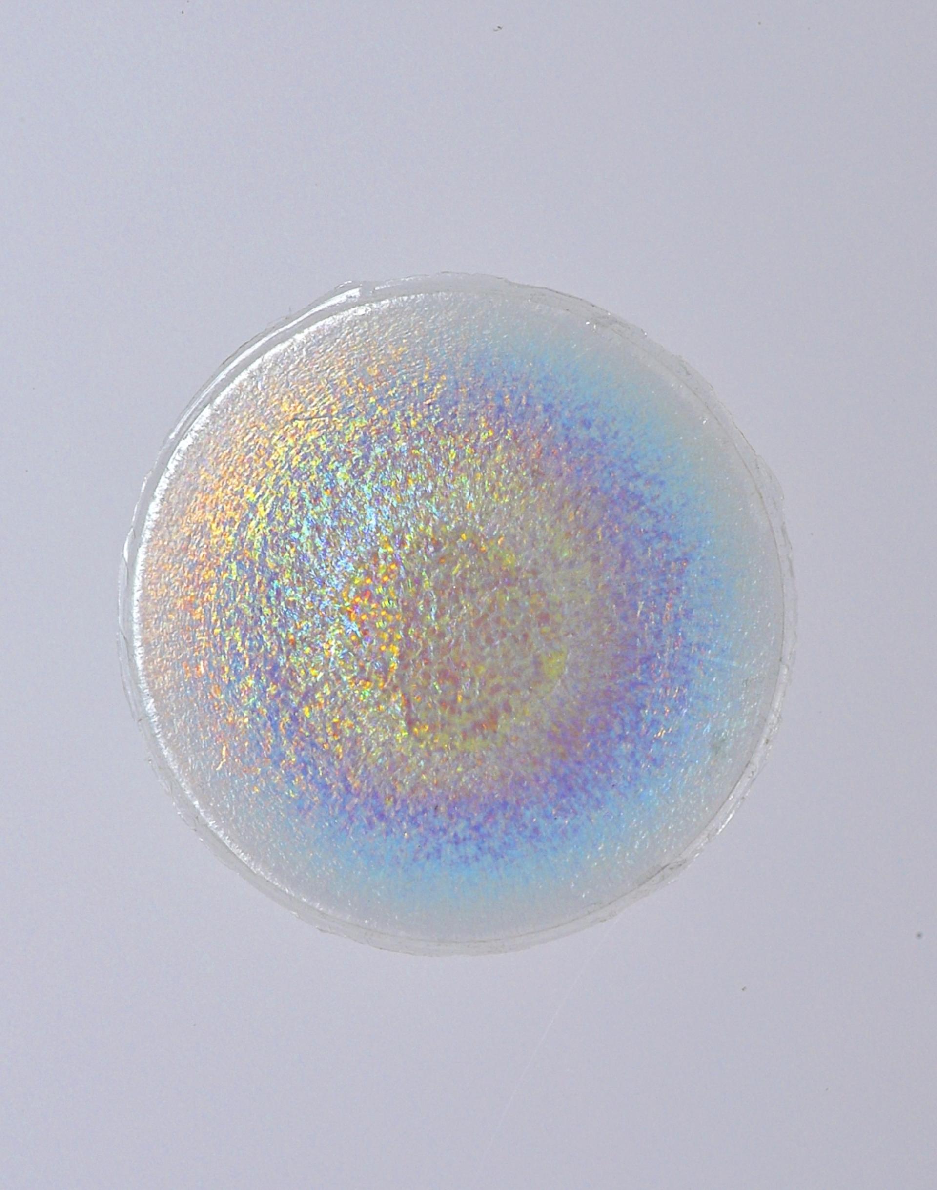 Colorful iridescent circular disc displayed against a white background, representing trends and innovations from 2019.