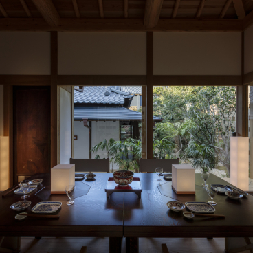 Elegant dining area in Azumi Setoda ryokan, showcasing modern design with a garden view and traditional table settings.
