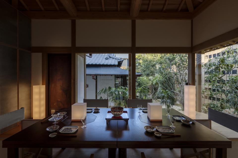 Elegant dining area in Azumi Setoda ryokan, showcasing modern design with a garden view and traditional table settings.