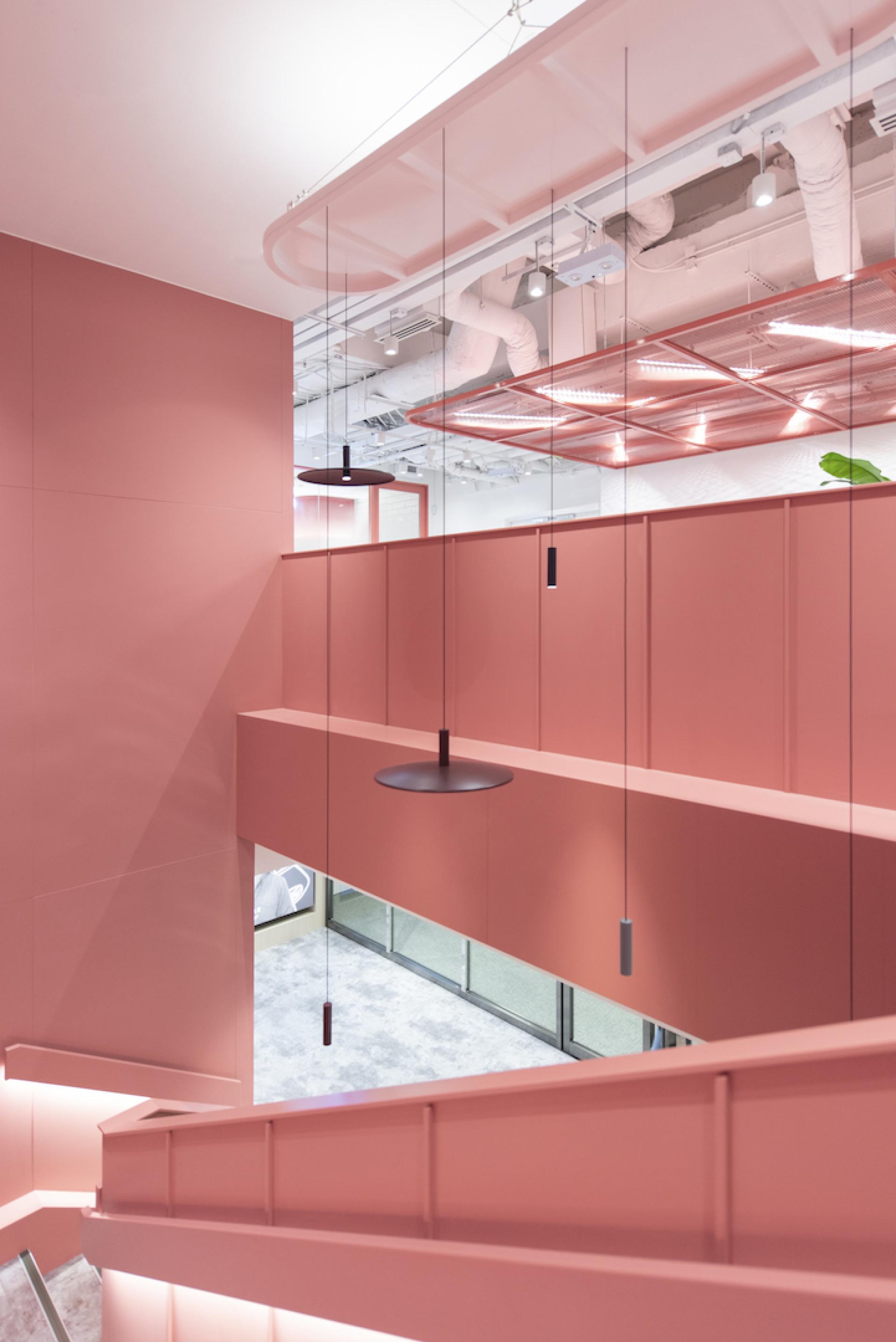Modern agile workspace design featuring pink walls and stylish pendant lighting by Bean Buro for Jardine Restaurant Group.