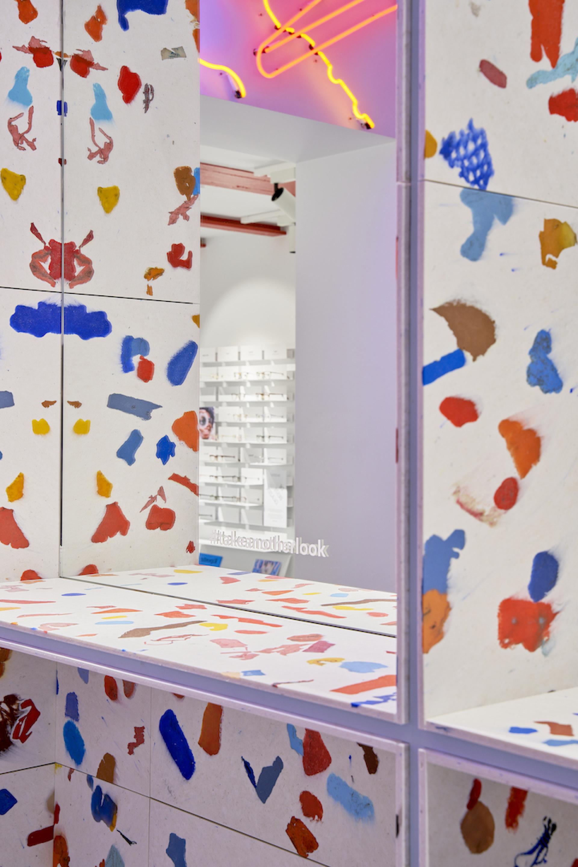 Colorful recycled wall and countertop in Amsterdam's eco-friendly eyewear store, showcasing responsible design with vibrant textures.