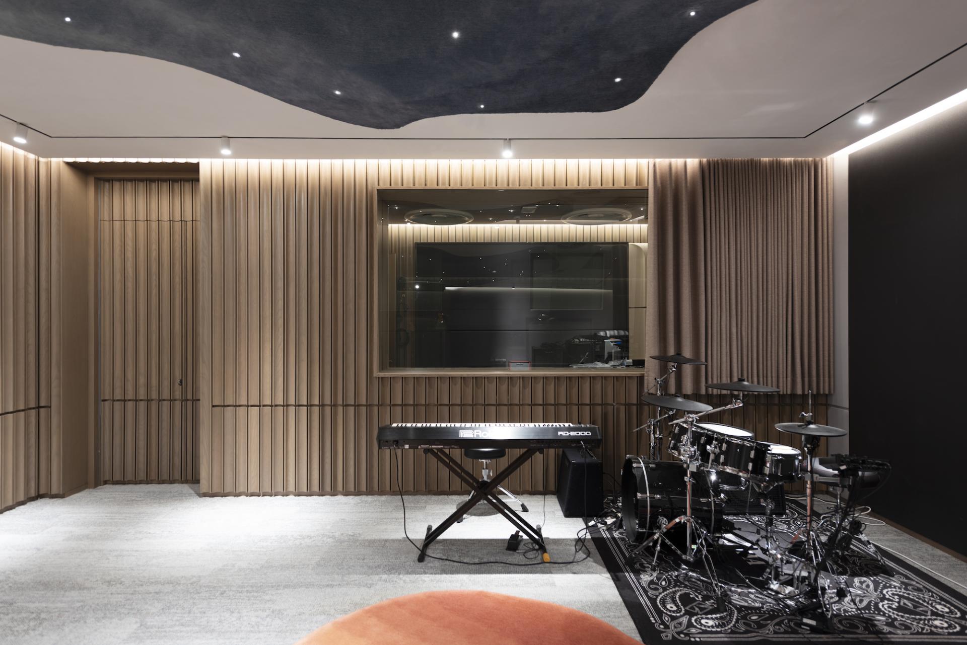 Modern music studio design featuring a keyboard and drum set, showcasing Bean Buro's creative workspace for Warner Music Hong Kong.